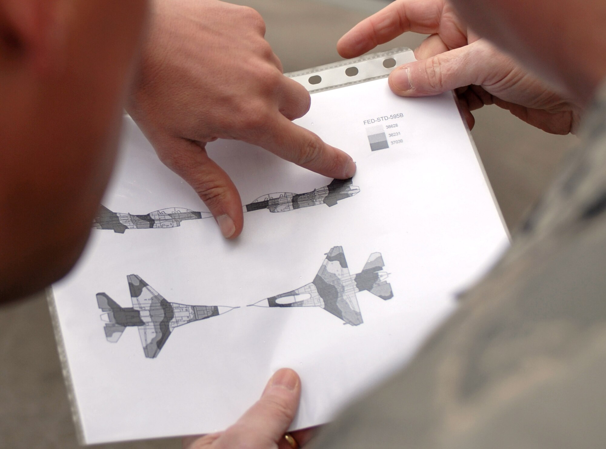 KUNSAN AIR BASE, South Korea -- Major General Loren Reno (right), Oklahoma City Air Logistics Center commander and Tech. Sgt. Brian Coffel (left), 8th Maintenance Squadron, look over the paint scheme diagram for the new artic paint scheme during his visit here Dec. 10.  The visit was for the ALC commanders to ensure units throughout the base have been receiving the proper resources needed to maintain its war fighting capability.  (U.S. Air Force photo/Senior Airman Steven R. Doty)