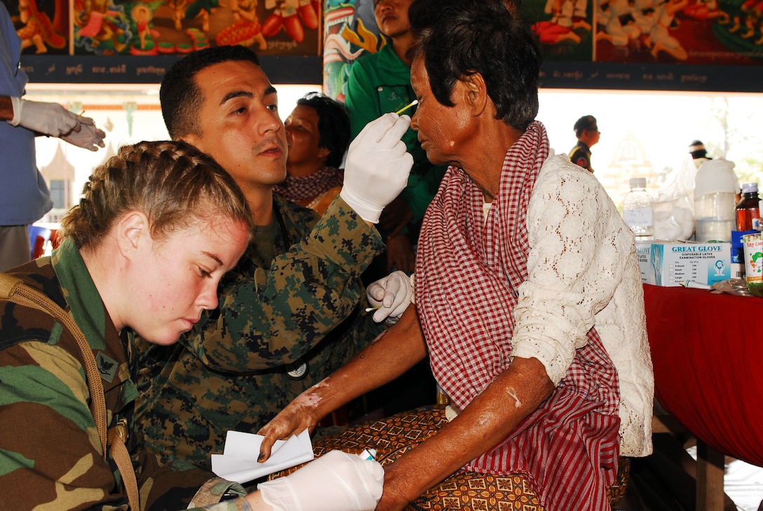 Navy Lt. Javier Agraz and Petty Officer 3rd Class Kristin M. McBeath, a hospital corpsman, both assigned to the USS Essex, apply medication to a patient's burns during a Medical and Dental Civic Action Project in Kampong Cham, Kingdom of Cambodia, Nov. 28, 2007. 