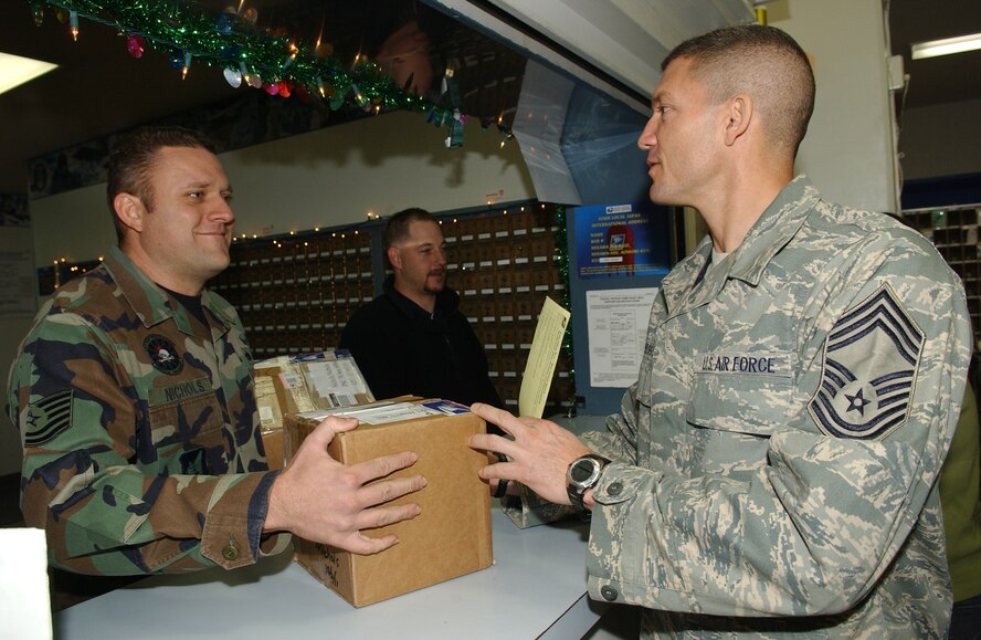 MISAWA AIR BASE, Japan -- Chief Master Sgt. Paul Boggs, 373rd Intelligence Group Chief Enlisted Manager, delivers a package to Tech. Sgt. Adam Nichols, 35th Maintenance Squadron, at the post office Dec. 13, 2007. In an effort to show leadership support and improve morale during the holiday season, commanders and chiefs from units all over base are volunteering at the post office during this historically busy time of year. As a reminder, the deadline for Express mail to be delivered in time for Christmas is Dec. 15, 2007. (U.S. Air Force photo by Senior Airman Robert Barnett)