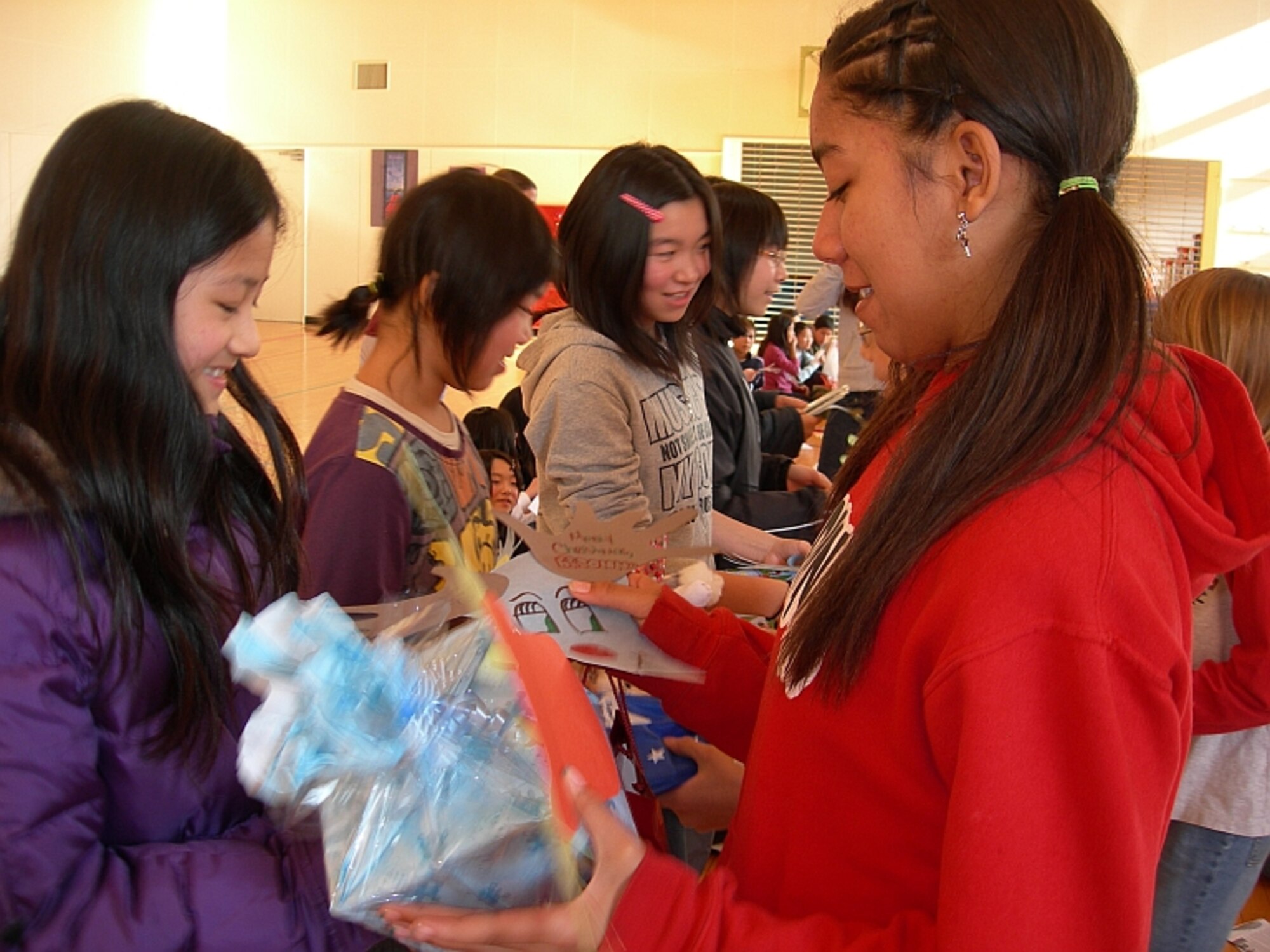 MISAWA AIR BASE, Japan -- Breonna Ruffin, an American Student, and Mizuki Kondo, a Japanese student, exchange gifts at a Christmas cultural exchange here Dec. 8, 2007. Not only did each child bring a gift from home to give, everyone made a Christmas decoration with a personalized message for their new friend to exchange as well. (Photo by Simon Bernard)
