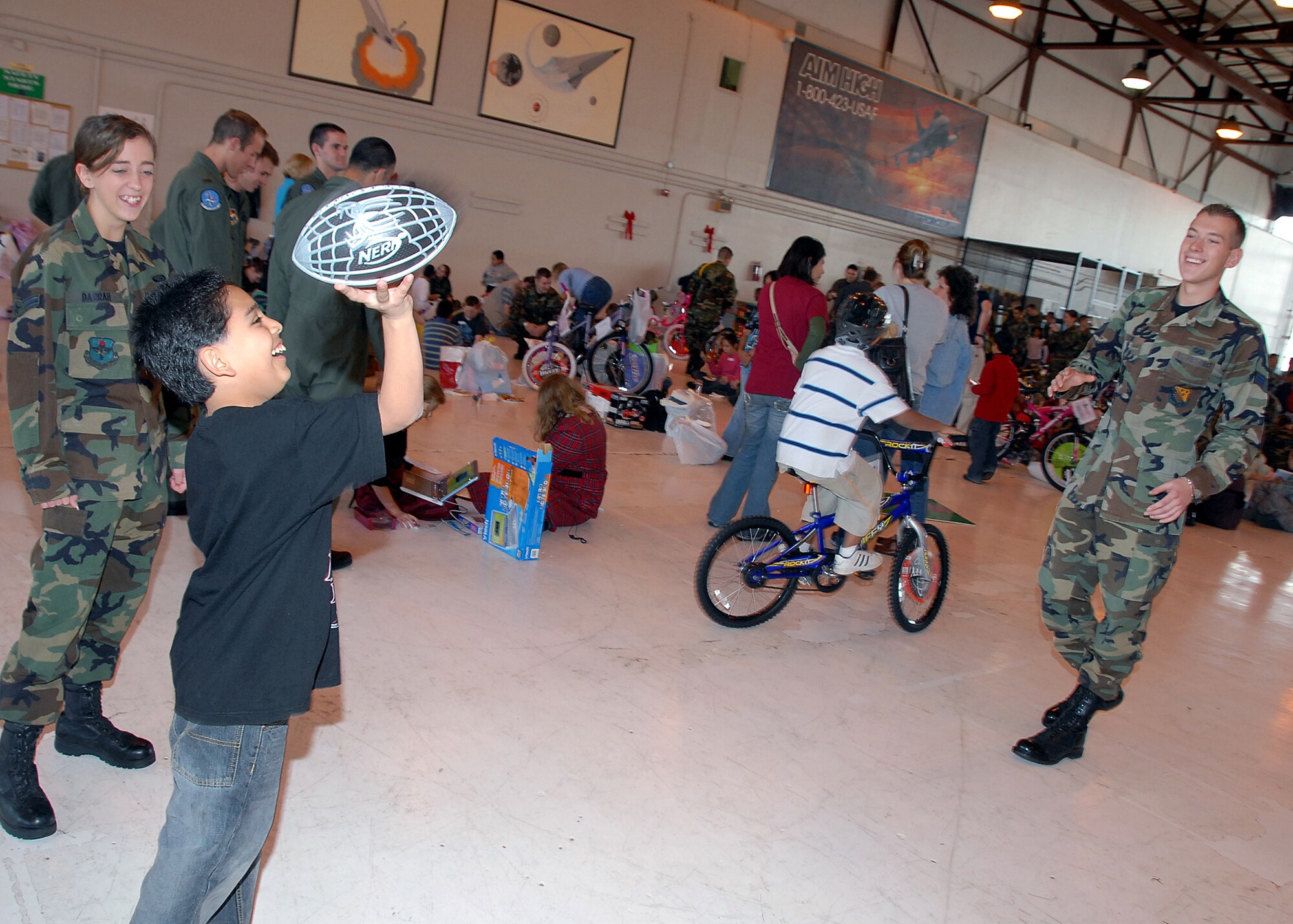Senior Airman John Fusik, a contracting specialist with the 82nd Contracting Squadron, and Airman 1st Class Katrina Darrah, 82nd Mission Support Group, play with their "adopted" child during the annual Give a Child a Christmas. (U.S. Air Force photo/Mike Litteken)