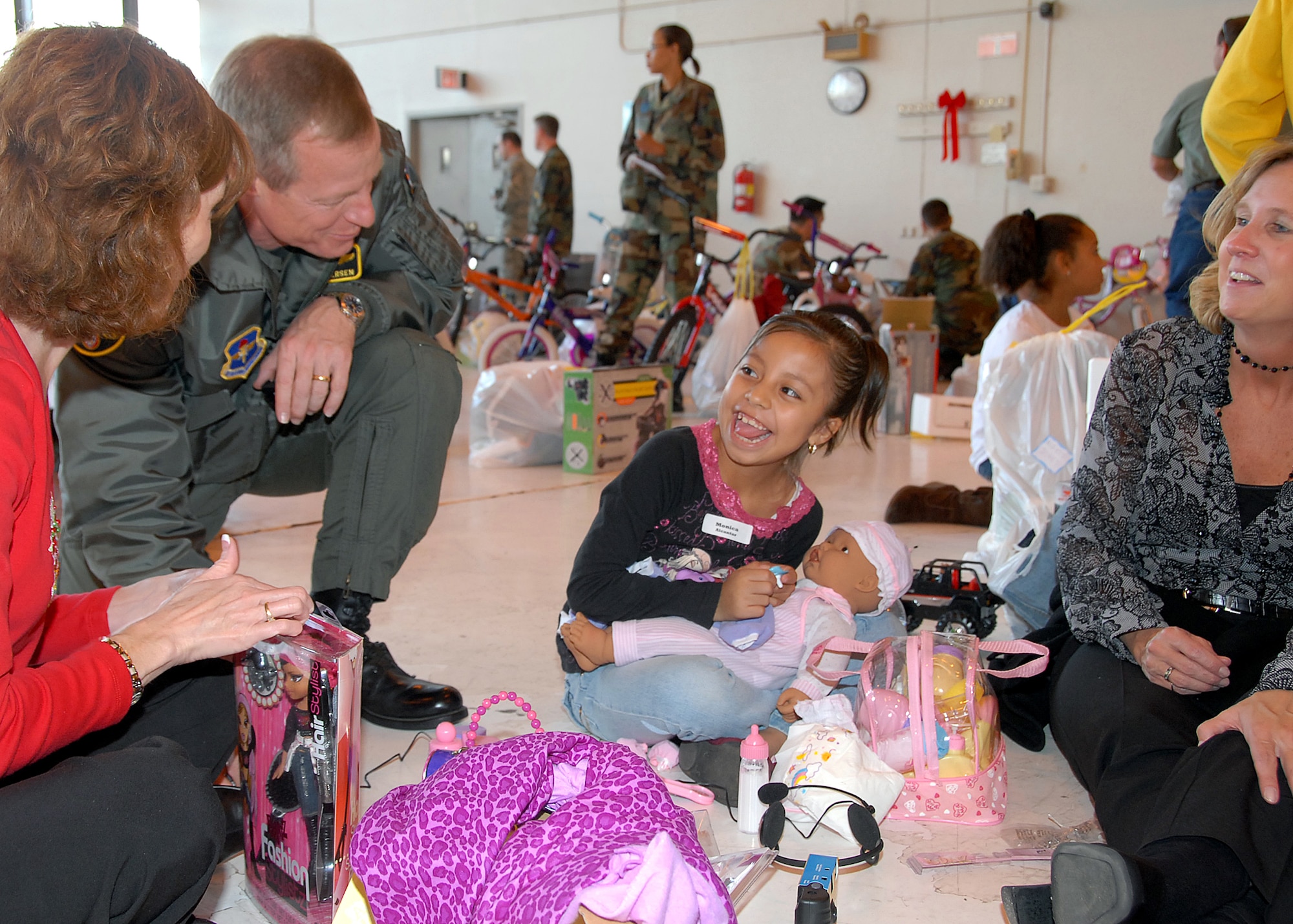 Col. David Petersen, 80th Flying Training Wing commander, checks in with one of the children during the Give a Child a Christmas event Dec. 10. (U.S. Air Force photo/Mike Litteken)