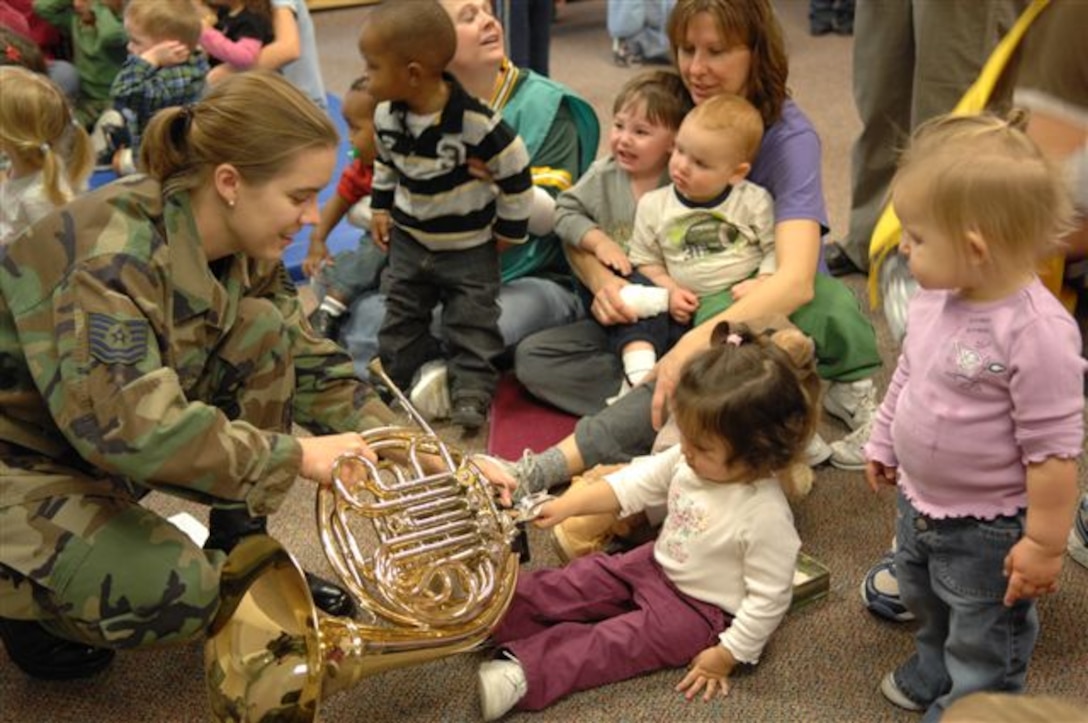 Technical Sgt Kimberly Beasley lets children push buttons on her horn after the Offutt Brass performed at the Child Developement Center at Ellsworth Air Force Base.  Offutt Brass is one of seven ensembles from the USAF Heartland of America Band that divided up to visit six Air Force bases in the midwest sharing the holiday spirit with military members and their families.