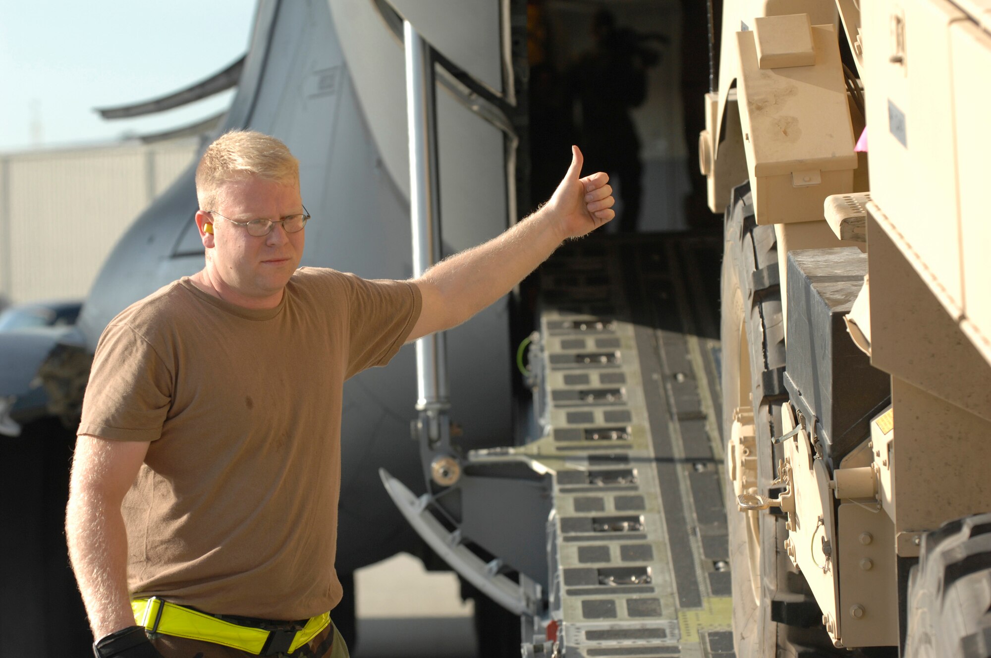 Staff Sgt. George Henderson, 437th Aerial Port Squadron ramp services technician, directs a Mine-Resistant Ambush Protected vehicle onto a C-17 aircraft from McGuire AFB, N.J., on the Charleston AFB flightline Dec. 6. (U.S. Air Force photo/James Bowman)
