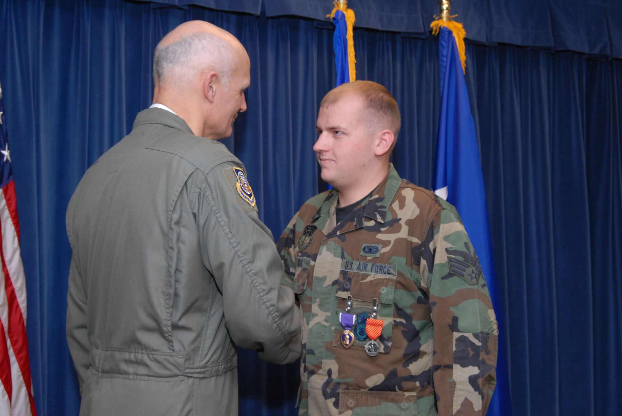 Senior Airman John Soules, 741st Missile Security Forces Squadron member, shakes hands with Maj. Gen. Roger Burg, 20th Air Force commander, Dec. 10 after receiving the Purple Heart and Air Force Combat Action Medal for wounds received in action June 28, 2007. He volunteered for the 365-day deployment to support Operation Iraqi Freedom. (U.S. Air Force photo/John Turner) 