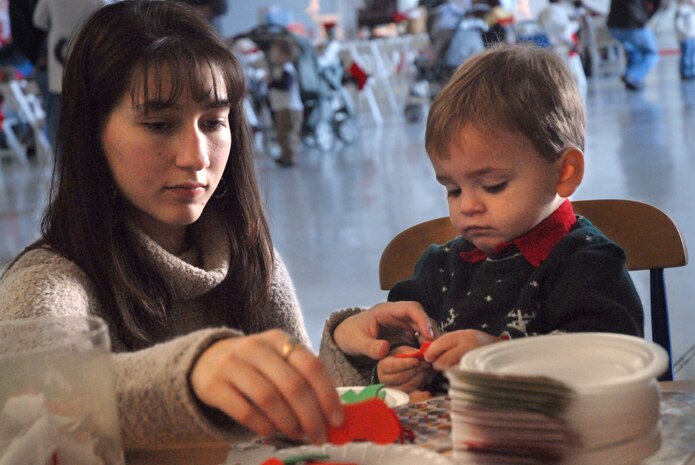 Aiden Amis, 1, son of Airman 1st Class J.T. Draffan, makes an ornament with his mom, Megan Draffan, at the Children's Holiday Party Saturday. (U. S. Air Force photo/Airman Melissa White)
