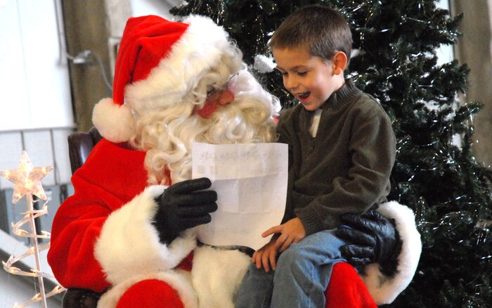Avery Strain, 5, son of Master Sgt. Justin Strain, shares his Christmas list with Santa during the Children's Holiday Party Saturday in Nose Dock 1. (U.S. Air Force photo/Airman Melissa White)