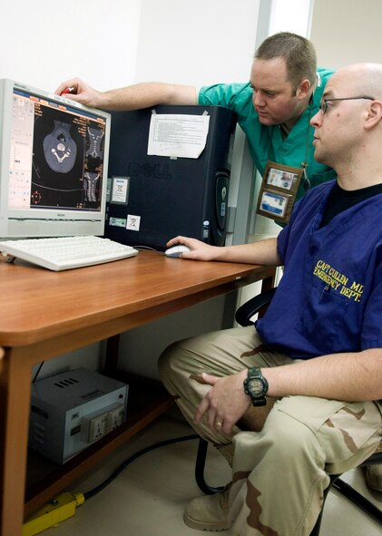 Capt. (Dr.) Shawn Cullen reviews the neck portion of a CT scan made on a Iraqi child with Capt. Thomas Folsom to check for any abnormalities or factures in the Air Force Theater Hospital at Balad Air Base, Iraq. Captain Cullen is an emergency room doctor with the 332nd Expeditionary Medical Squadron and is deployed from Keesler Air Force Base, Miss., and Captain Folsom is a 332nd EMDG emergency room nurse deployed from Patrick AFB, Fla. (U.S. Air Force photo illustration/Senior Airman Travis Edwards) 