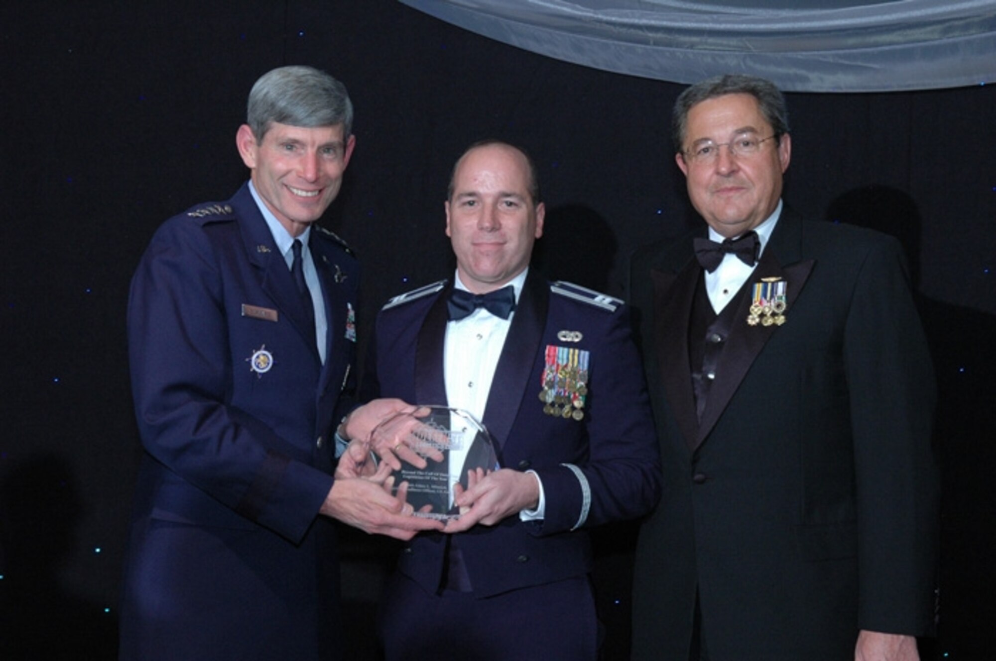 Capt. Adam Minnich, 509th Logistic Readiness Squadron, receives the 2007 Defense Logistics “Beyond The Call of Duty: Logistician of the Year” award from Gen. Norton A. Schwartz, United States Transportation Command commander, and retired Vice Adm. Edward M. Straw, former Defense Logistics Agency Director at an awards banquet in Washington, D.C., Nov. 27.
