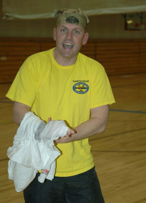 Master Sgt. Chris Morgan, 28th Bomb Wing, puts on a shirt during the fitness survivor challenge, Dec. 07.  In this event teams have to untangle shirts put them on and run 1 lap around the track, the team that gets 5 members back first wins. (U.S. Air Force photo / Airman 1st Class Joshua Seybert)