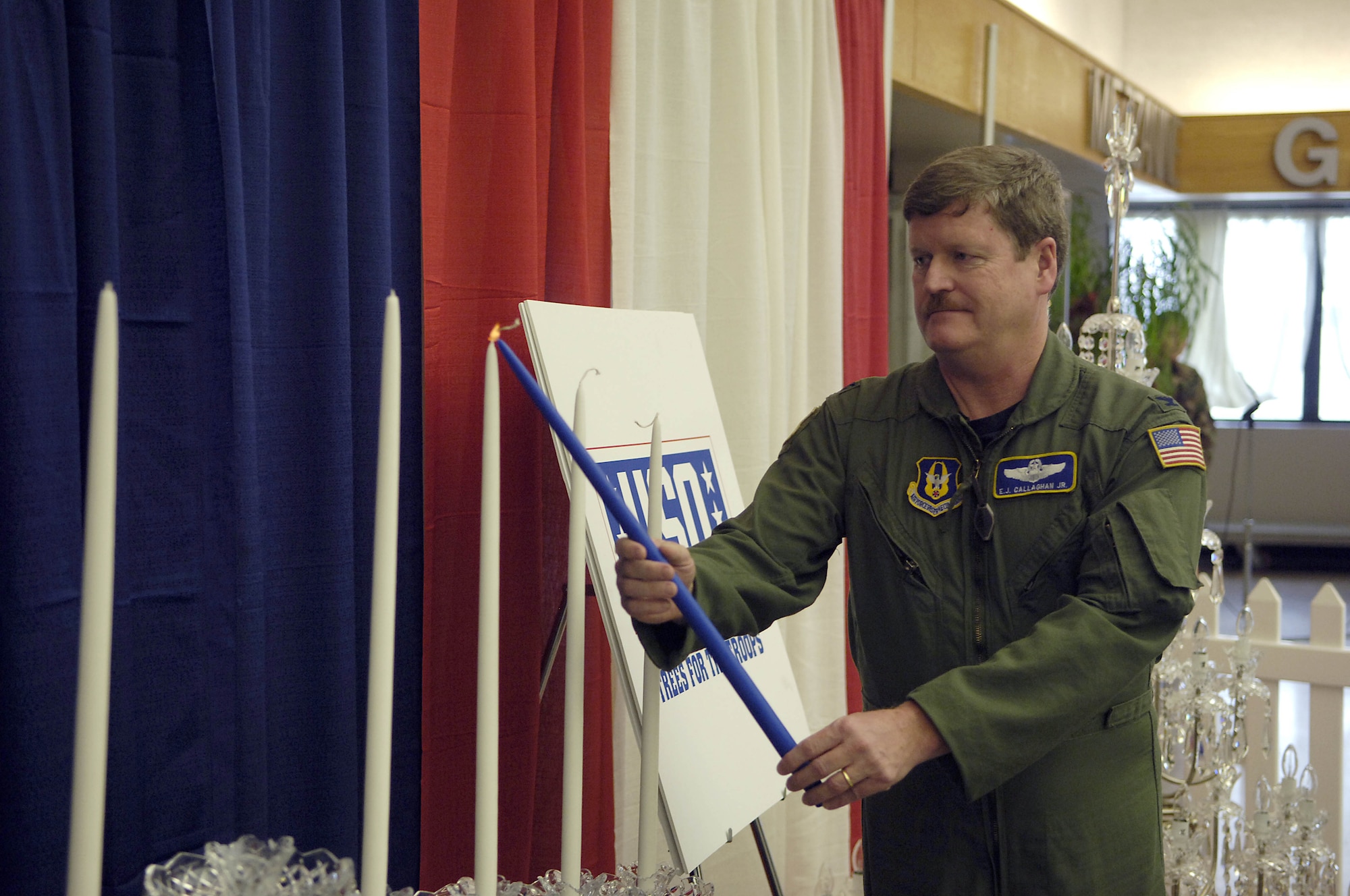 MCGUIRE AFB, N.J. -- A Waterford Crystal Menorah is lit by Air Force Reserve Col. E. J. Callaghan, vice commander, 514th Air Mobility Wing Dec. 7 during a lighting ceremony at McGuire Air Force Base's passenger terminal. Waterford Wedgford USA in association with the Liberty USO donated a crystal menorah and a crystal Christmas tree for display until Jan. 3. (U.S. Air Force photo/Kenn Mann)
