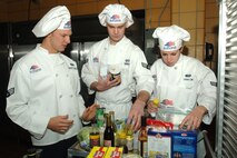 MINOT AIR FORCE BASE, N.D. -- (From left) Senior Airman Bryant Whittaker, 741st Missile Squadron, Senior Airman Travis Keele, 742nd MS, and Airman 1st Class Amanda Kovalcin, 740th MS, all chefs, pick out ingredients during a Warrior Chef competition here Dec. 8. The Warrior Chef Competition was formatted similarly to an Iron Chef competition. (U.S. Air Force photo by Airman 1st Class Sharida Bishop)