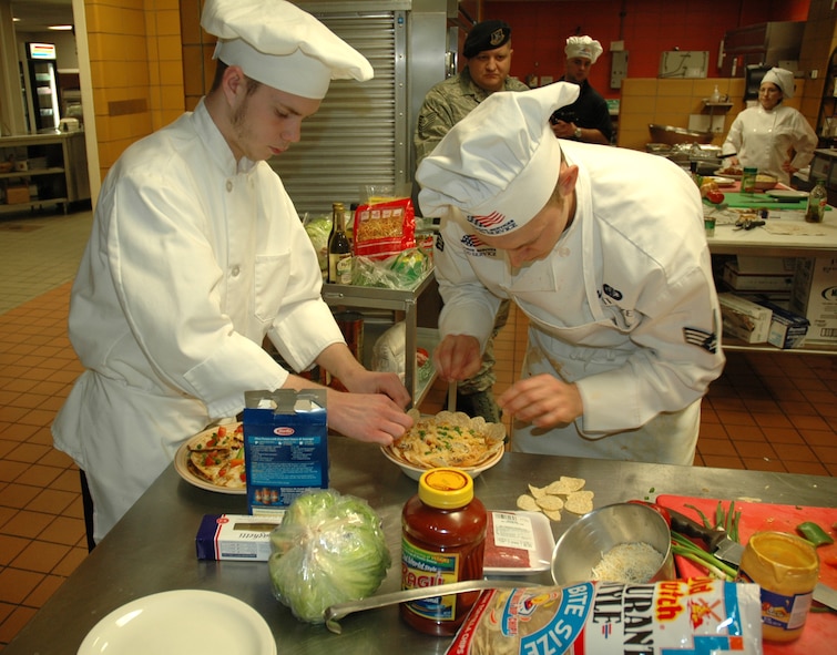 MINOT AIR FORCE BASE, N.D. -- (From left) Sous-chef Jeffery Packard and Senior Airman Bryant Whittaker, 741st Missile Squadron chef, work together to put the finishing touches on their entrees during a Warrior Chef competition Dec. 8. Airmen Whittaker and Mr. Packard beat out the competition to take first place. (U.S. Air Force photo by Airman 1st Class Wesley Wright)