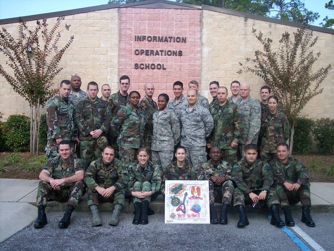 The first Undergraduate Network Training Courses poses in front of the 39th Information Operations school house where they spent the last eight weeks training to protect and defend the Air Force’s networks. The class decorated a ceiling tile that will be placed in the classroom where they and future UNWT classes are taught. (Air Force Photo)
