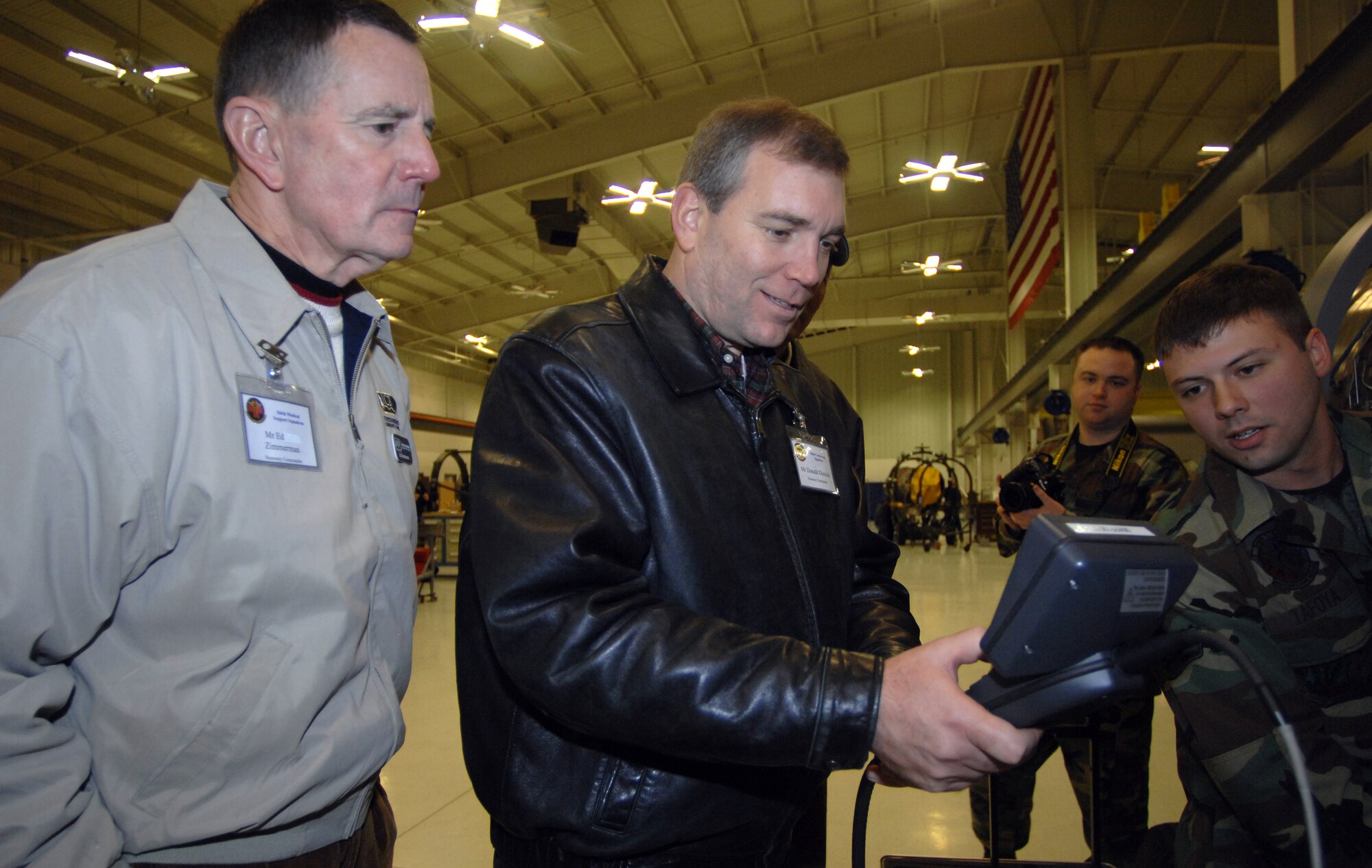 MOUNTAIN HOME AIR FORCE BASE, Idaho -- Senior Airman Christopher Tafoya, 366th Component Maintenance Squadron Propulsion Shop, provides honorary commanders Donald Dietrich and Ed Zimmerman a hands-on demonstration of how to use a borescope to inspect an F-15 engine for potential problems during their tour here, Dec 7. The visit provided more than 20 of the wing’s honorary commanders an interactive, hands-on experience of maintenance operations and the opportunity to meet the Airmen who make it happen. (U.S. Air Force photo/ Airman 1st Class Ryan Crane)