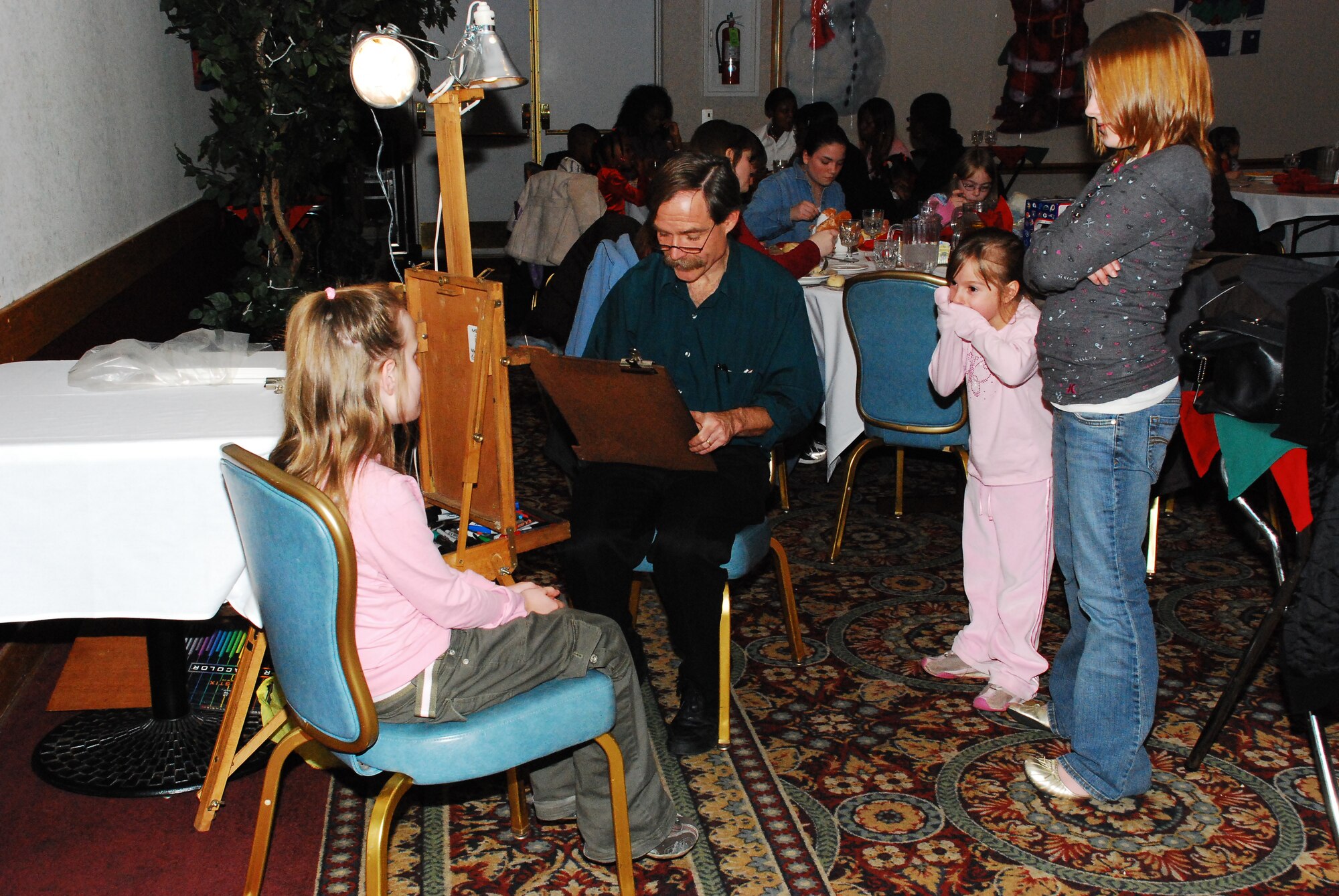 An artist also participated during the annual Hearts Apart Christmas Party, drawing caricatures of participating children. The McGuire and Family Readiness Center hosted the event; helping families of deployed Airmen celebrate the holidays. (U.S. Air Force photo/Airman 1st Class Rebekah Phy)