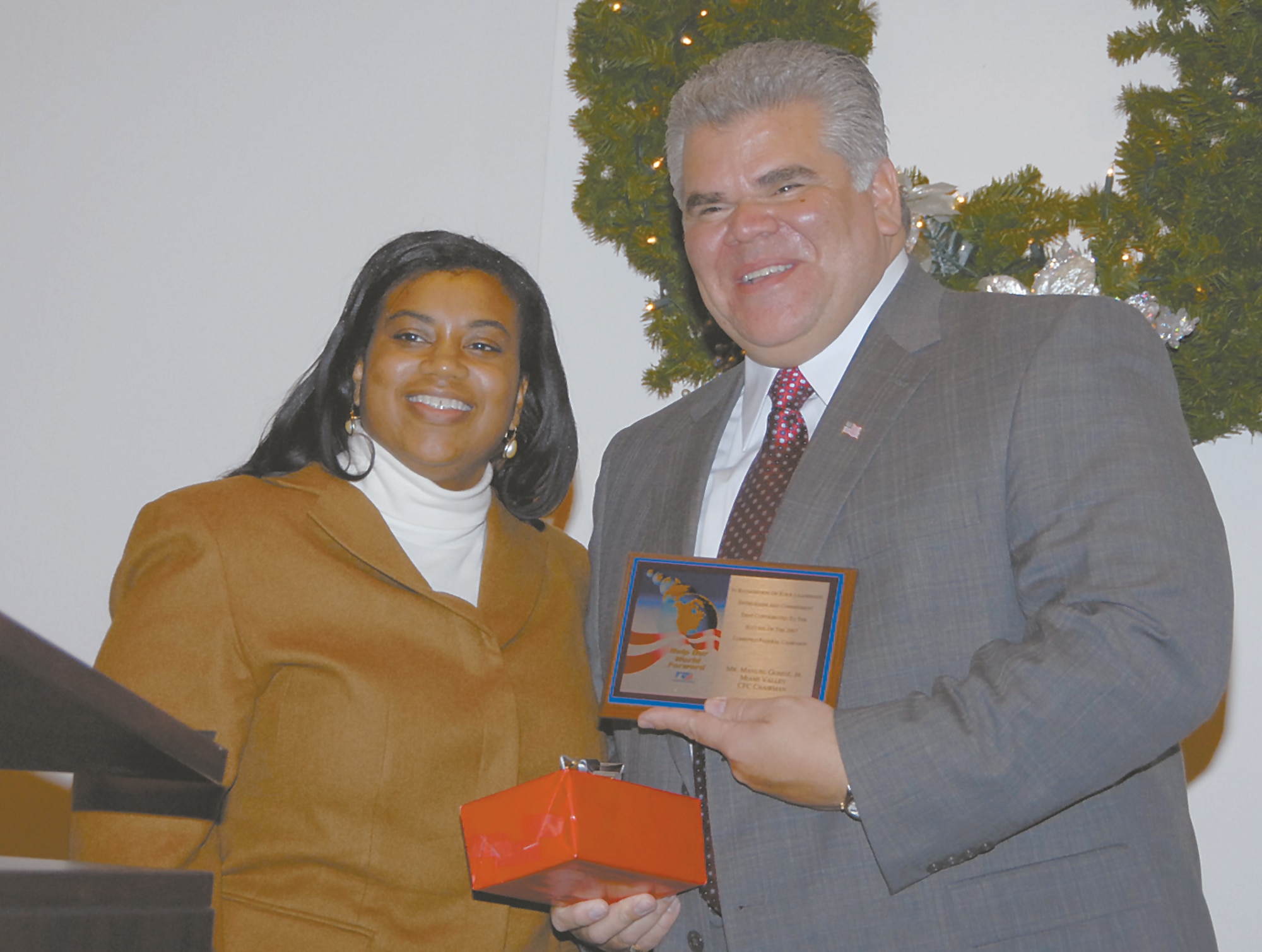 Jacqueline Phillips, executive director of CFC, presents a gift to Manuel Gomez, Jr., the campaign chairman, at Thursday's awards breakfast.  (Skywrighter photo by Christy Webb)