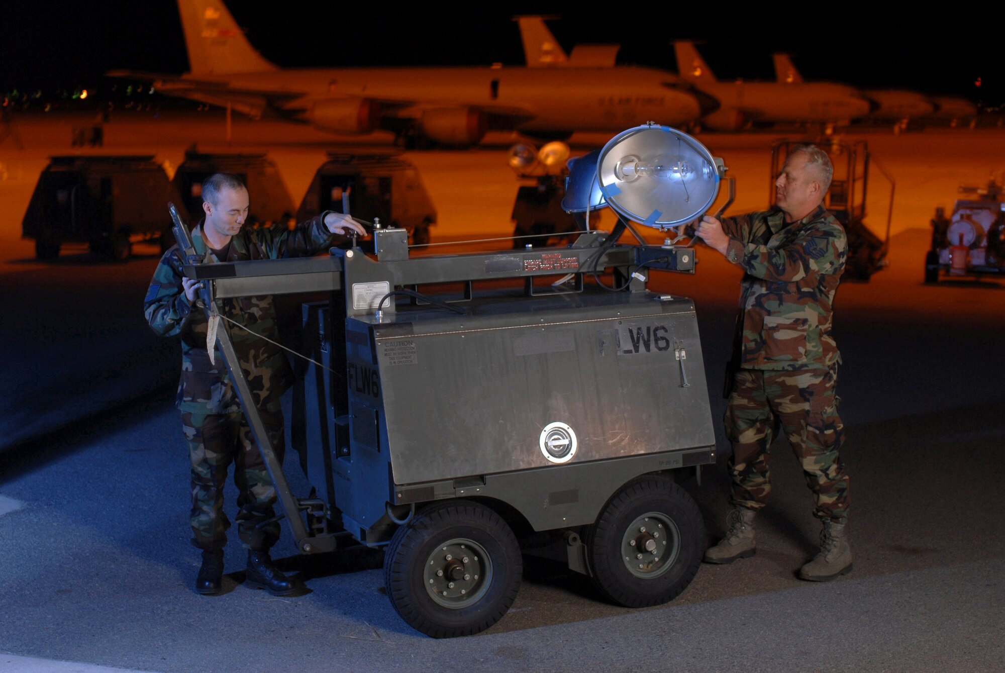 Tech. Sgt. Tom Wilson (left) and Master Sgt. Tom Maple inspect lighting equipment Dec. 5 at March Air Reserve Base, Calif. Both are aircraft generation equipment technicans from the 452nd Maintenance Squadron and air Reserve technicians here. Air Reserve technicians are full-time civilian employees of the Air Force who must maintain active status as reservists in the Air Force Reserve unit in which they are employed. They are permanent employees who, in the event of mobilization, are available for active duty in their assigned military position. They are essential for the operational readiness of their Reserve unit. In the background are KC-135 Stratotankers from the 336th Air Refueling Squadron. (U.S. Air Force photo/Val Gempis) 