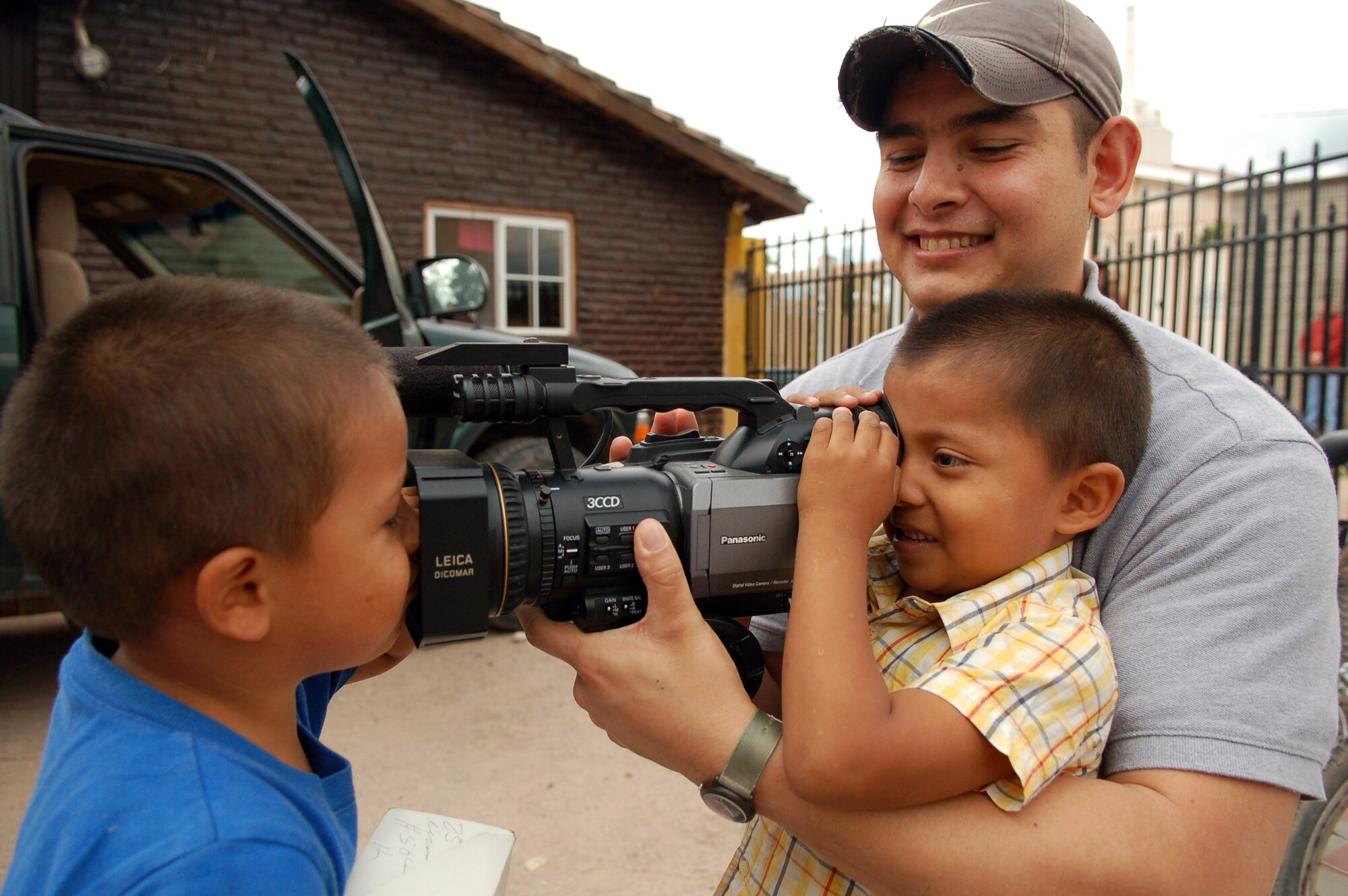 COMAYAGUA, Honduras – Army Sgt. William Nash, Armed Forces Network Honduras, shows two Honduran boys the camera he uses to do his job as a videographer.  Servicemembers from U.S. Southern Command and Joint Task Force-Bravo delivered more than 130 pairs of shoes to Hogar de Niños Tierra Santa orphanage here Dec. 8.  (U.S. Air Force photo by Staff Sgt. Austin M. May)