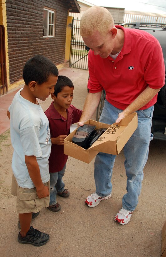 COMAYAGUA, Honduras – Air Force Chaplain (Capt.) Chad Bellamy, Joint Task Force-Bravo chaplain, admires a young Honduran boy’s new pair of shoes, a gift from U.S. Southern Command and JTF-Bravo.  Servicemembers from both commands delivered more than 130 pairs of shoes to Hogar de Niños Tierra Santa orphanage here Dec. 8.  (U.S. Air Force photo by Staff Sgt. Austin M. May)