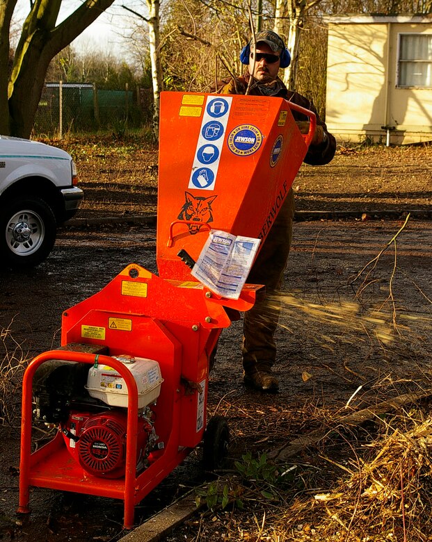 Tech. Sgt. John Quakkelaar, 95th RS, feeds branches into a chipper at Riverside Middle School Dec. 7. Members from the 95th RS helped out in the local community Dec. 6 and 7 by cutting down trees, branches and bushes at the local school that had become overgrown. (U.S. Air Force photo by Karen Abeyasekere)