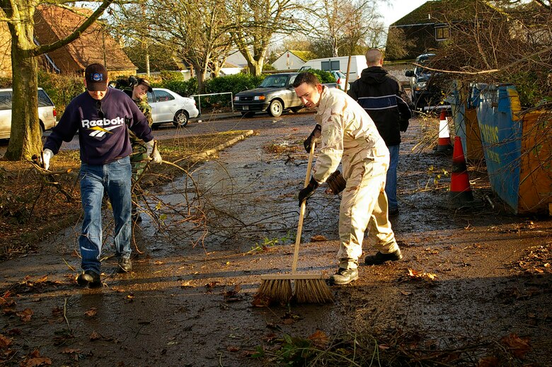 Members from the 95th RS clear up branches and leaves from the back of Riverside Middle School Dec. 7. Squadron members helped the local community by spending two days clearing up the area of the local middle school. (U.S. Air Force photo by Karen Abeyasekere)