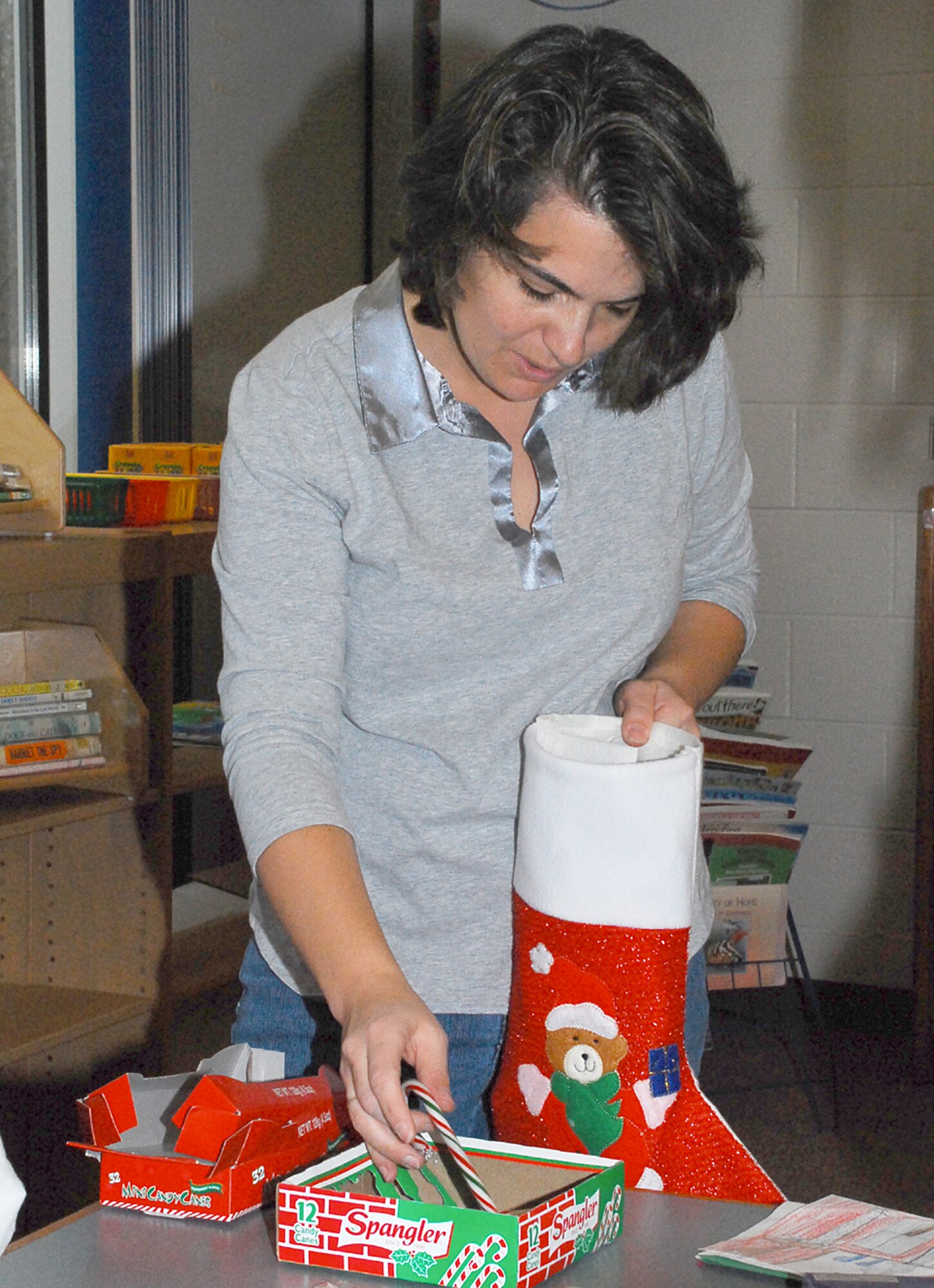 Lydia Norway, a parent helper, stuffs goodies into a stocking destined to cheer a deployed servicemember at the Columbia Elementary School here recently. Children at the school gathered together to prepare 30 stockings to send overseas in a program dubbed "Stockings for Soldiers". (U.S. Air Force photo/Senior Airman Danielle Johnson)