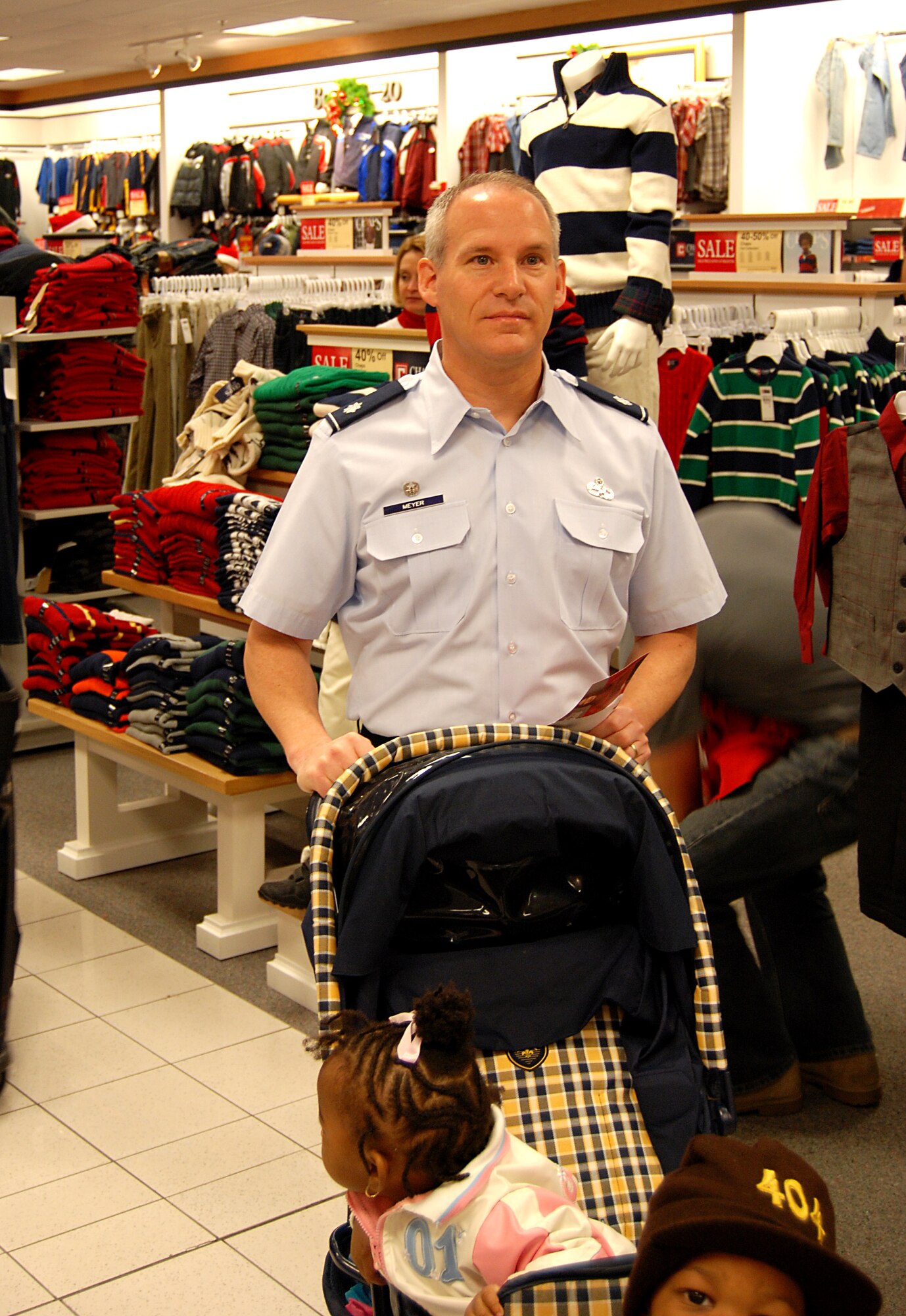 Lt. Col. Paul Meyer, commander of the 94th Maintenance Squadron, volunteered his time pushing a stroller and shopping during Shop With A Hero, an event to help buy Christmas gifts for needy families. The event took place Dec. 8 at the Kohl's department store in Acworth, Ga.  During Shop With A Hero, hundreds of Airmen, Soldiers, Marines and Sailors joined with local public safety personnel to escort young people as they were given a $100.00 gift card to buy gifts for their families. 
     "I encourage more Air Force members to participate next year," said Colonel Meyer.  "My family and I will definitely volunteer again.  Its a positive reflection on Dobbins and the military." 
     Colonel Meyer added that the most rewarding part of the experience was watching the children enjoy shopping for their parents and other family members.  