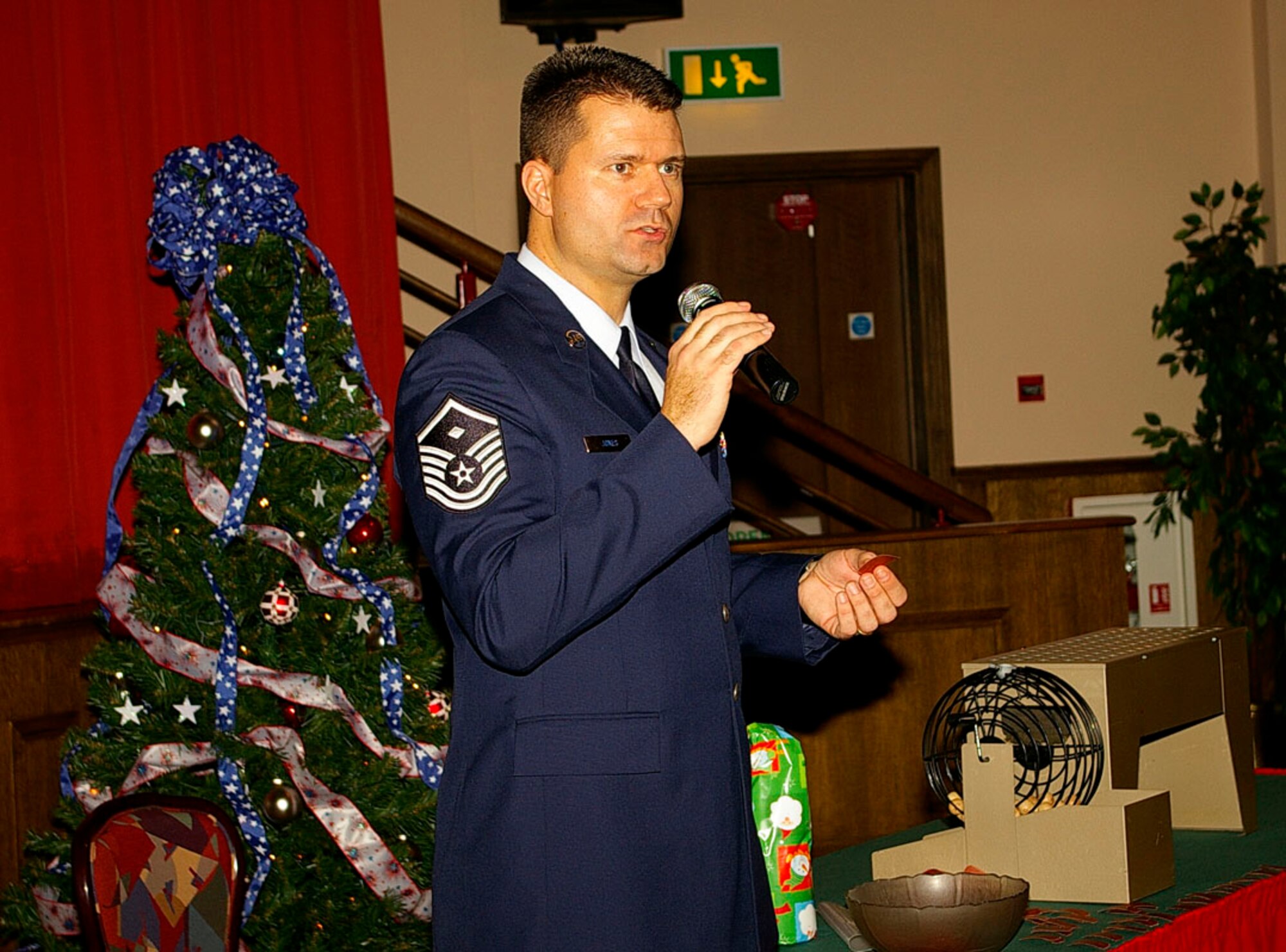 Master Sgt. Beau Jones, 100th Services Squadron first sergeant, reads out ticket numbers during a bingo session at the senior citizens' luncheon Dec. 5 at the Galaxy Club. (U.S. Air Force photo by Karen Abeyasekere)