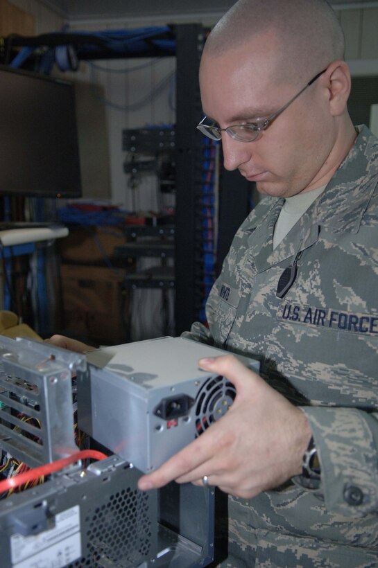 BALAD AIR BASE, Iraq -- Senior Airman Justin White, a 332nd Expeditionary Communications Squadron small computers technician, removes a faulty power supply from a desktop computer here. On average, the small computers flight repairs five to 10 computers a day. Airman White is deployed from Langley Air Force Base, Va. (U.S. Air Force photo/Senior Airman Terri Barriere)