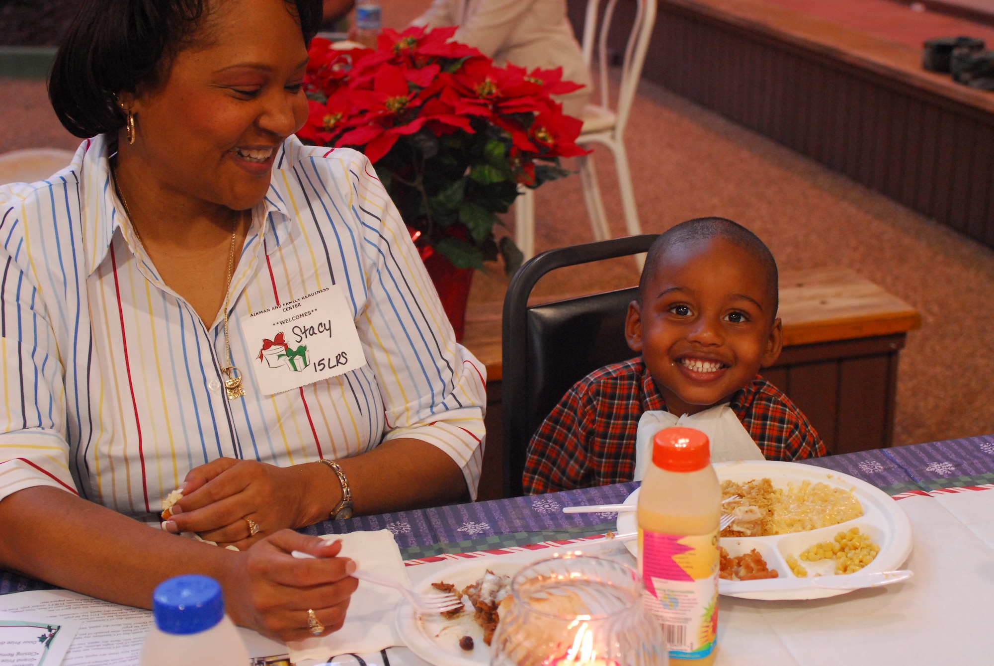 Caiden Stephen breaks into a smile as his grandmother Stacy Ayers smiles while watching him during Wednesday night’s Airman Family Readiness Center   Heart’s Apart Holiday party for deployed spouses.  Caiden is the son of Staff Sergeant Candice Ayers, 15th Logistics Readiness Squadron deployed to Southwest Asia. (U.S. Air Force Photo/Staff Sgt. Erin Smith)