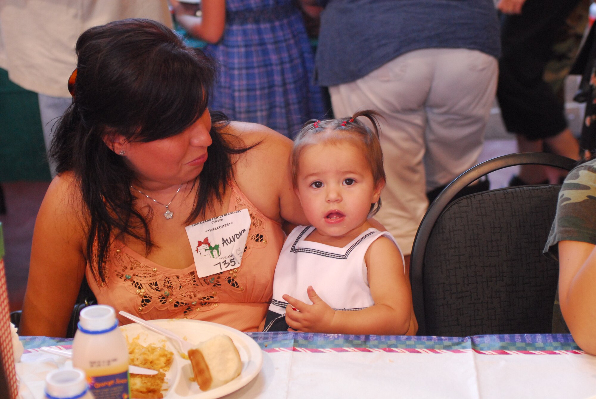 Aurora and daughter Isabella Baty the family of Senior Airman Michael Baty 15th Maintenance Squadron deployed to Southwest Asia, eat dinner  at this month’s   Airman Family Readiness Center   Heart’s Apart Holiday party, Wednesday evening,  Dec. 12, 2007.