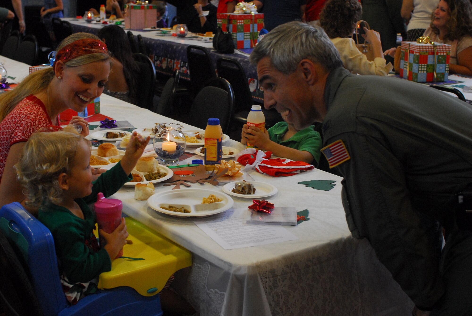 Colonel J.J. Torres, 15th Airlift Wing commander, shares a light moment with Camden Colaw the daughter of Capt Patrick Colaw  deployed to Southwest Asia at Wednesday night’s  (Dec. 12 2007) Airman Family Readiness Center Hearts Apart Holiday Party in the Airman and Family Readiness Center's Lani. (U.S. Air Force Photo by SSgt Erin Smith)