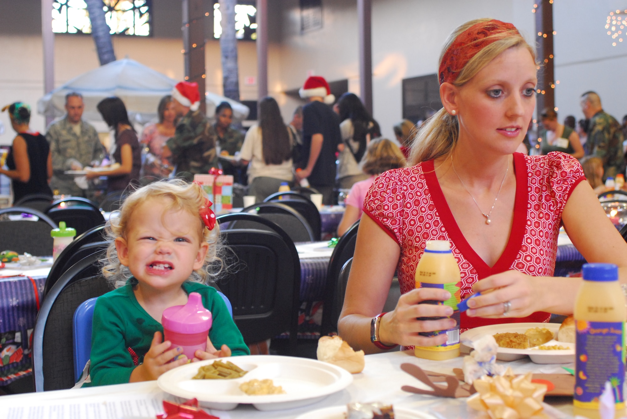 When it comes to smiling for a photo opportunity Camden Colaw, the daughter of Capt. Patrick Colaw 15 Airlift Wing Legal office deployed to Southwest Asia gives it her all for the camera, during the Airman Family and Readiness Center Holiday dinner, Wednesday evening, Dec. 12, 2007. (U.S.  Air Force Photo by SSgt Erin Smith)

