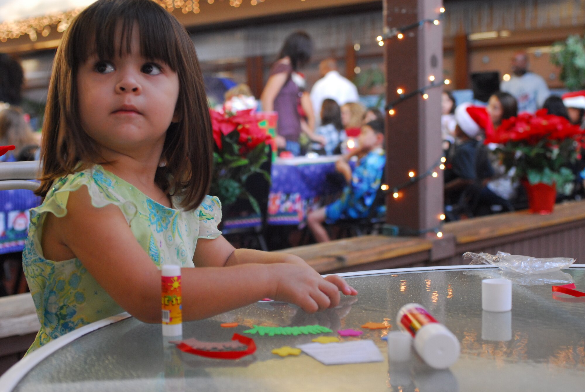 Amara Harris the daughter of Staff. Sgt Raleigh Harris, 324 Intelligence Squadron deployed to Southwest Asia,  glanced up at her mom, Jessica while she was putting together a Christmas tree ornament at this month’s  Airman Family Readiness Center  Heart’s Apart Holiday evening party.  More than 80 spouses and their families attended the party Wednesday evening, Dec. 12, 2007. (U.S.  Air Force Photo by SSgt Erin Smith)
