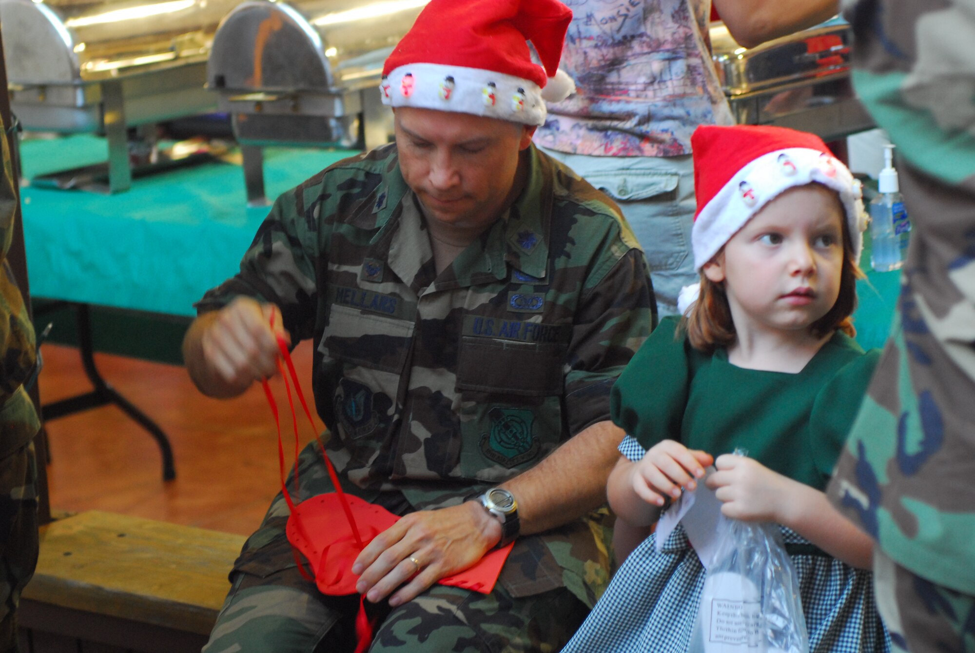 Lt. Col Douglas Mellars, 15th Communications Squadron Commander, helps his daughter Ali  put together a stocking during this month’s Airman Family Readiness Center   Heart’s Apart Holiday evening party for deployed spouses.  Colonel Mellars and his family attended the party in support of the 15th CS deployed spouses in the Hearts Apart program. (U.S.  Air Force Photo by SSgt Erin Smith)