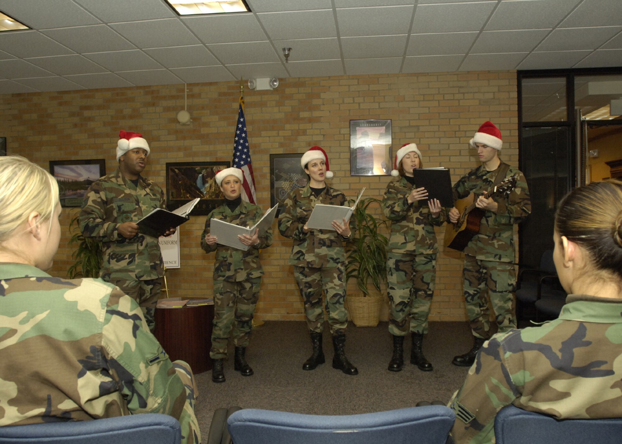 FAIRCHILD AIR FORCE BASE, Wash - A holiday vocalist group from Travis Air Force Base, Calif., perform for Airmen in the 92nd Comptroller Squadron. The group of vocalists spent the entire day Dec.11 touring the base and singing Christmas carols to the Airmen. (U.S. Air Force photo / Senior Airman Eunique Stevens)