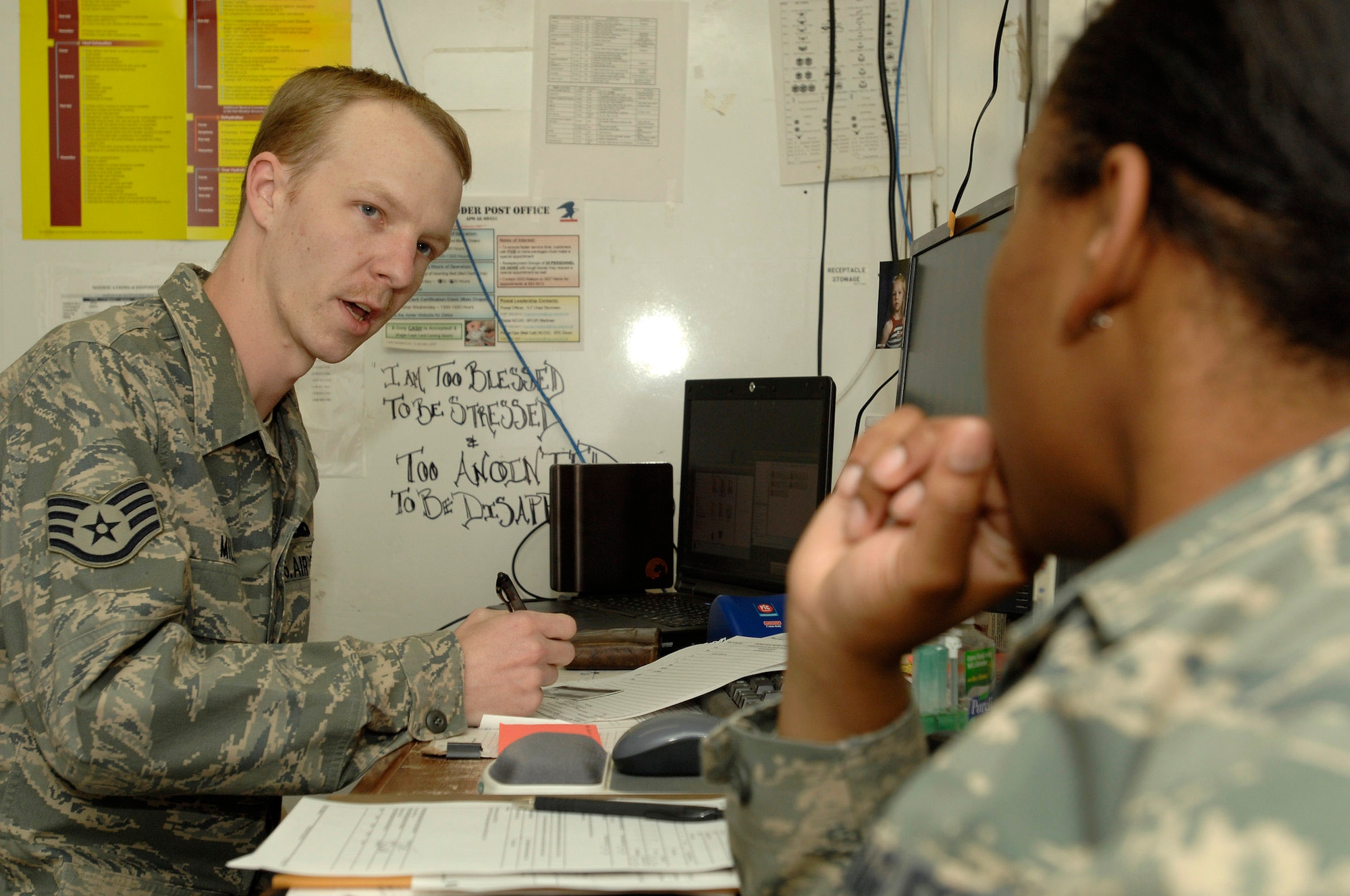 Staff Sgt. Brian Miller asks the patient a series of questions and fills in the paperwork based on her answers Dec. 11 at the 407th Expeditionary Medical Squadron Clinic at Ali Base, Iraq. Sergeant Miller is a medical technician and assists with vaccinations, minor procedures and documentation of medical care. Sergeant Miller is deployed from Seymour Johnson Air Force Base, N.C. (U.S. Air Force photo/Airman 1st Class Jonathan Snyder) 