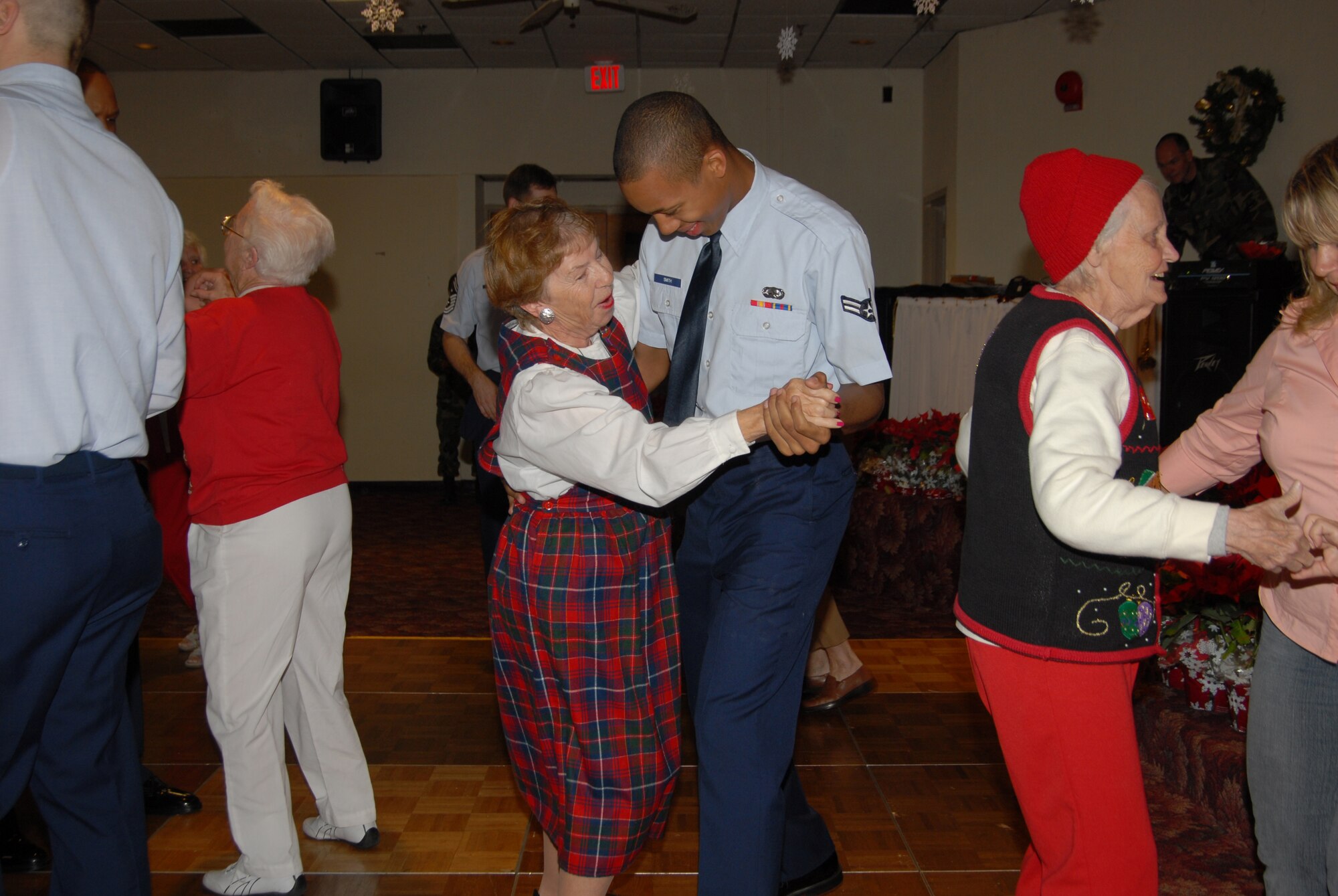 Airman 1st Class Andrew Smith, First Term Airmen Center student, joins a guest in a slow dance during the Golden Age Christmas party.  Every year, the Bay County Council on Aging and Sims Veterans' Nursing Home brings guest to Tyndall Air Force Base for the event. (Photo by Susan Trahan)
