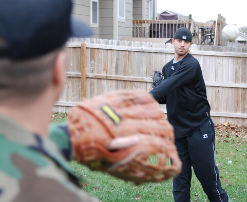 Ronnie Morales throws a fast pitch to his father Master Sgt. Labaca, 22nd Contracting Squadron, in their back yard Nov. 21. During the Major League Baseball off-season from the Chicago White Sox, the left handed pitcher attends Wichita State University where he majors in Physiology. (photo by Airman 1st Class Jessica Lockoski)