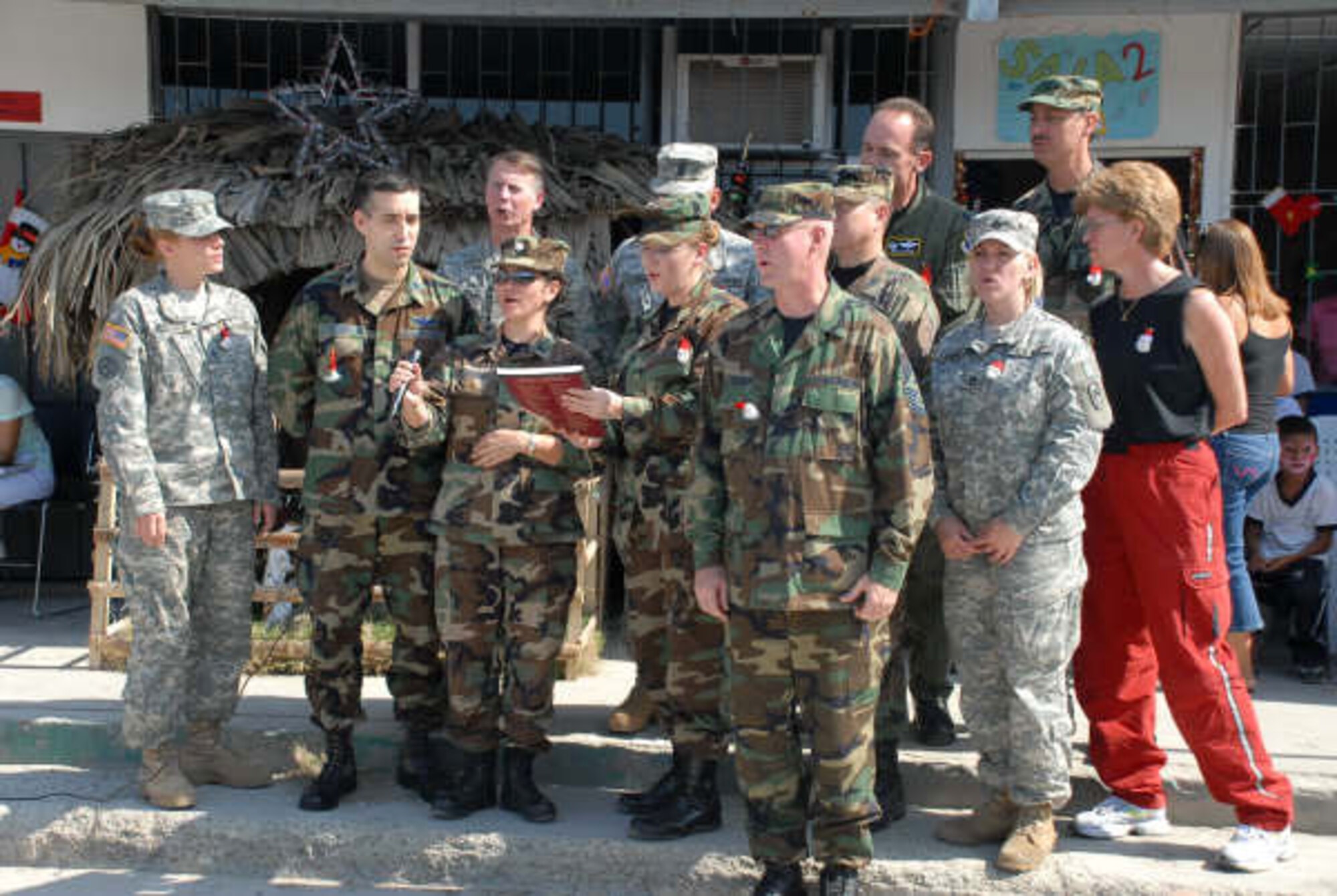 A group of U.S. Southern Command servicemembers, including deputy commander Lt. Gen. Glenn F. Spears and Army Command Sgt. Maj. Michael Balch were joined Dec. 11 by Airman from Forward Operating Location Manta, in singing Christmas carols to the students of the Angelica Flores School for the Disabled in Manta, Ecuador. The group was there to present certificates pledging money for repairs and school supplies to the schoool. (U.S. Navy photo/Petty Officer 1st Class Michael Wimbish.) 