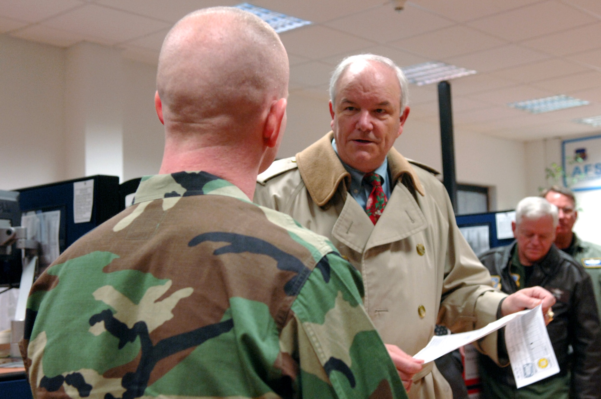 Secretary of the Air Force Michael W. Wynne (right) talks to Maj. Jeffrey Carter about the vehicle registration process by the 569th U.S. Force Protection Squadron Dec. 11 at Ramstein Air Base, Germany. Using Air Force Smart Operations for the 21st century, unit members cut the time required to register a vehicle from about two hours to less than 30 minutes. (U.S. Air Force photo/Airman 1st Class Kelly LeGuillon) 
