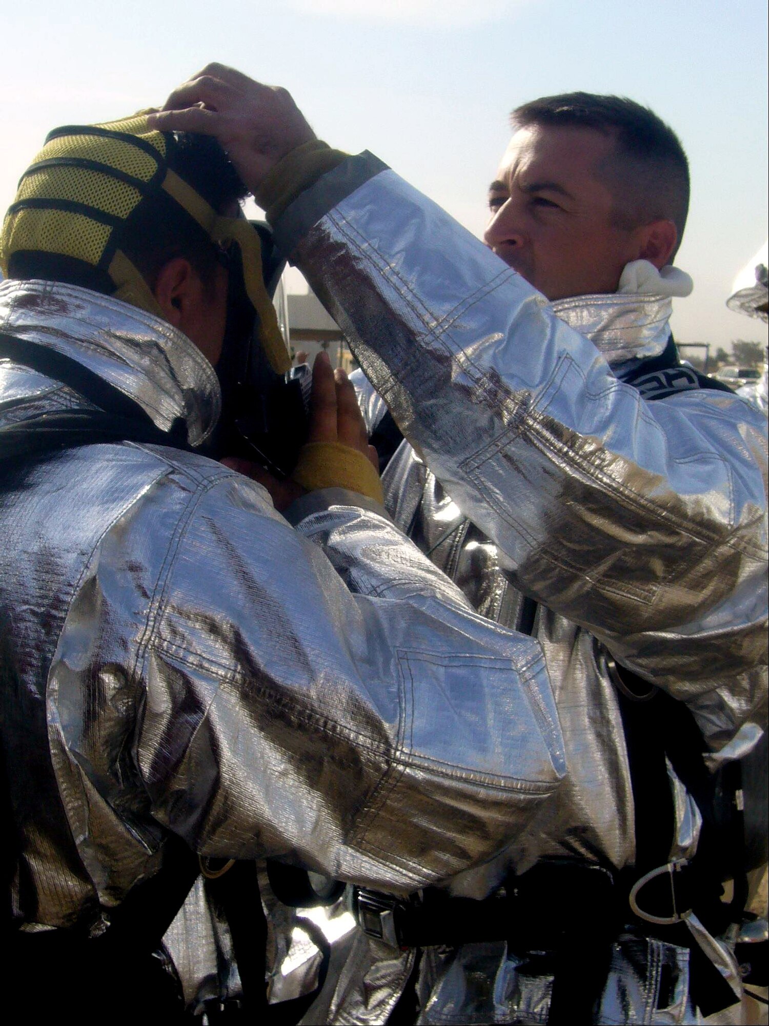 Master Sgt. Philip Fourroux helps prep one of his students for a fire demonstration recently at the Iraqi Air Force Training School at Taji Air Force Base, Iraq. The first 10 Iraqi firefighters graduated from the school Dec. 11. Sergeant Fourroux is a 370th Expeditionary Training Squadron basic technical training fire instructor. (U.S. Air Force photo) 
