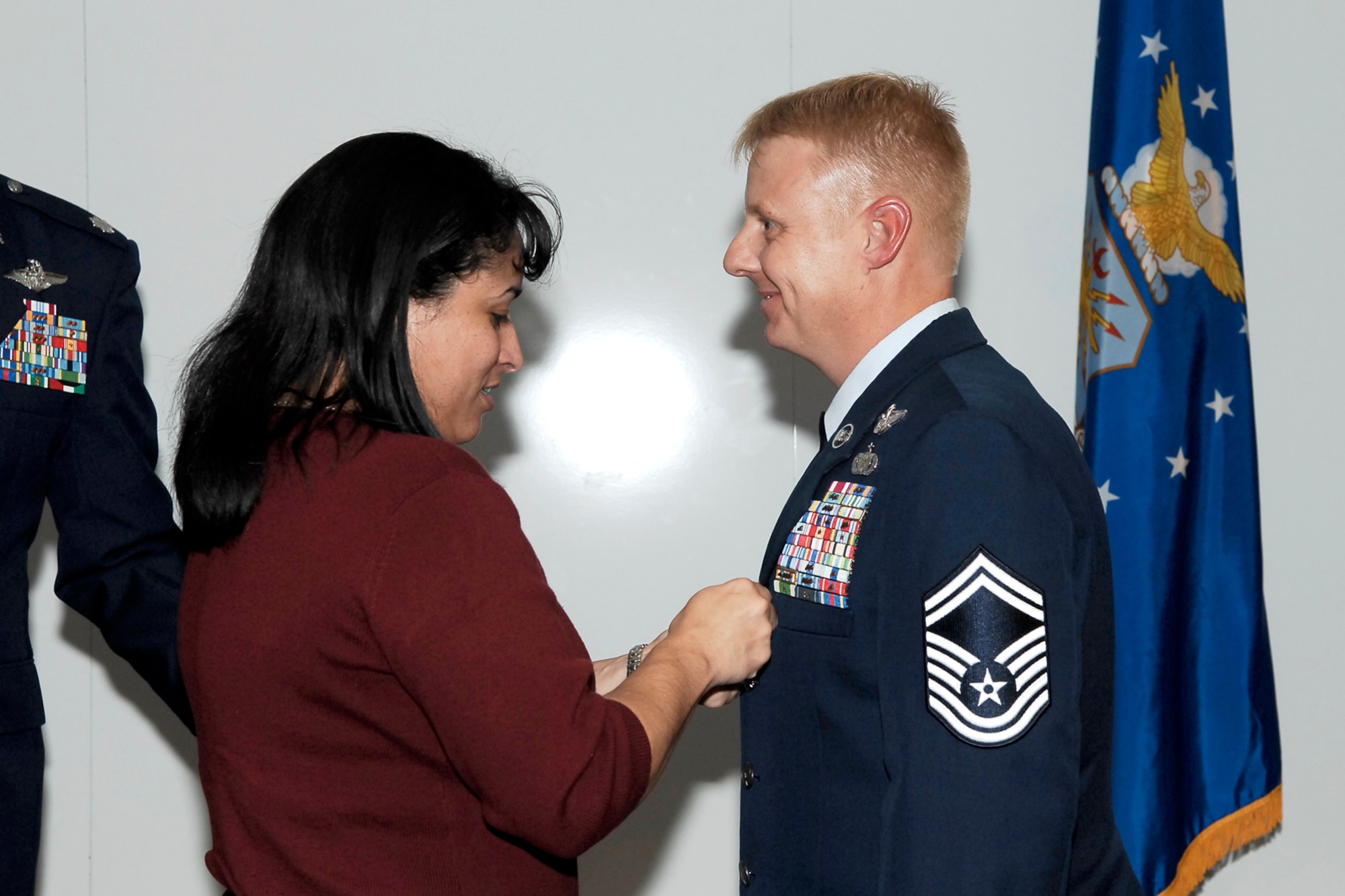 Senior Master Sgt. Sean Wong has the Bronze Star placed on his service jacket by his wife, Marcy, during the “Heroes Past and Present” event Dec. 7. Sergeant Wong received the Bronze Star for exceptional meritorious achievement to the United States as a Combat Aviation Advisor and C-130 Standardization and Evaluation Loadmaster during Operation IRAQI FREEDOM. (U.S. Air Force photo by Lorna Sanchez)