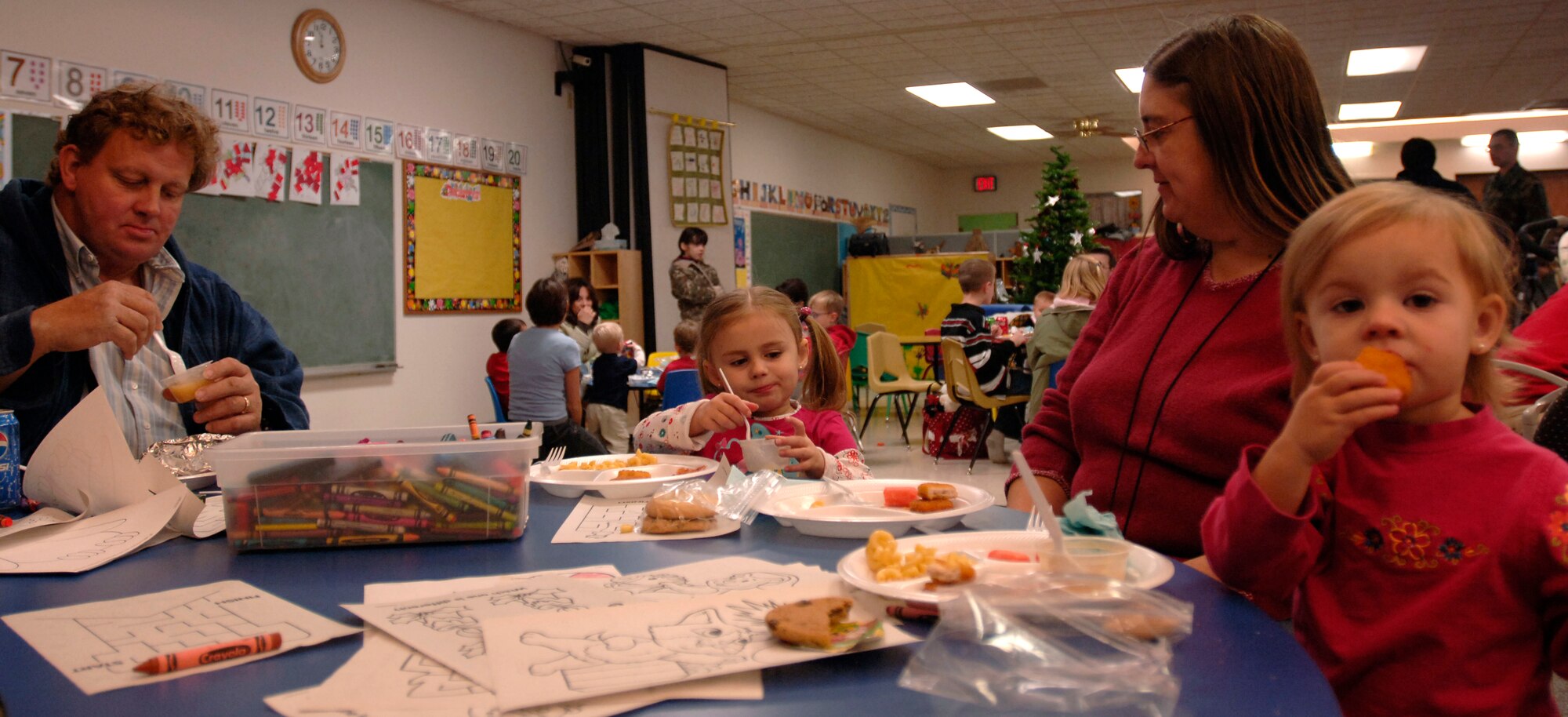 MCCONNELL AIR FORCE BASE, Kan. -- Michael and Kay Brooks eat lunch with their grandchildren Haley and Laura, daughters of Tech. Sgt. Jeremy Ramseyer and Staff Sgt. Laura Ramseyer, 22nd Logistics Readiness Squadron, the family colors together during the Hearts Apart program at the children’s playgroup building Dec. 8. (Photo by Airman 1st Class Maria Ruiz)