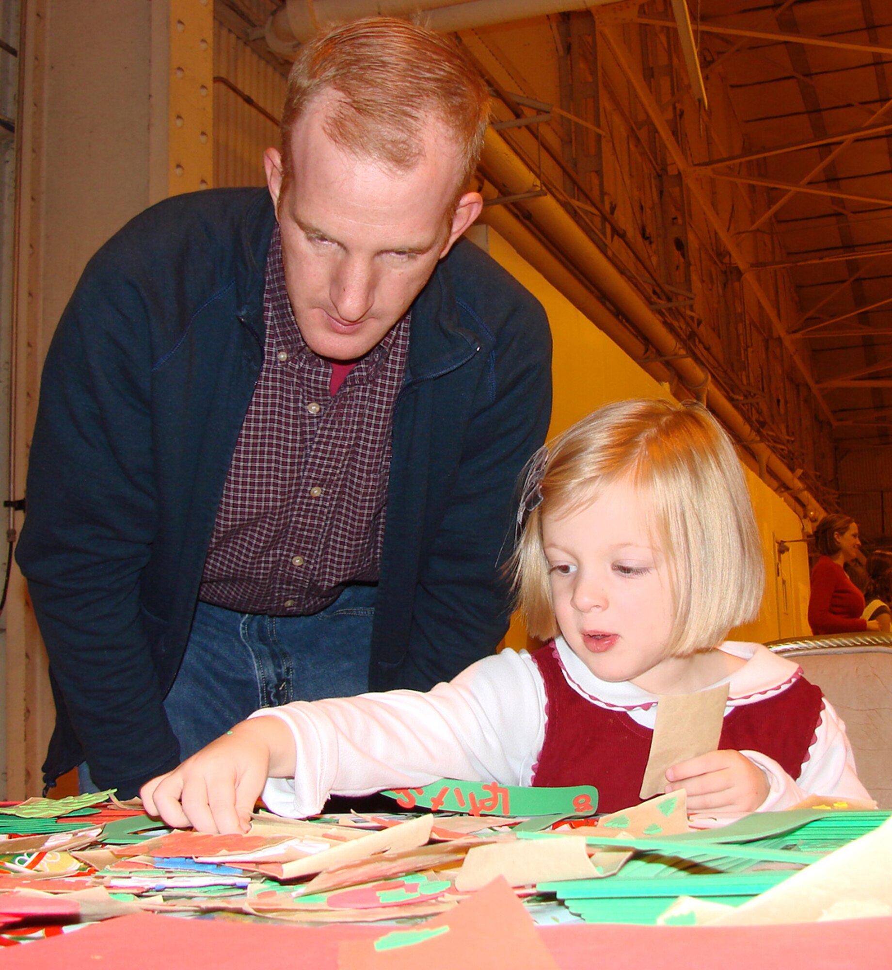 Maj. Joe DiNatalie helps his daughter, Mariel, 3, create a holiday project during "Breakfast with Santa" Dec. 8 in Hangar 170. (U.S. Air Force photo by Tech. Sgt. Mary Davis) 