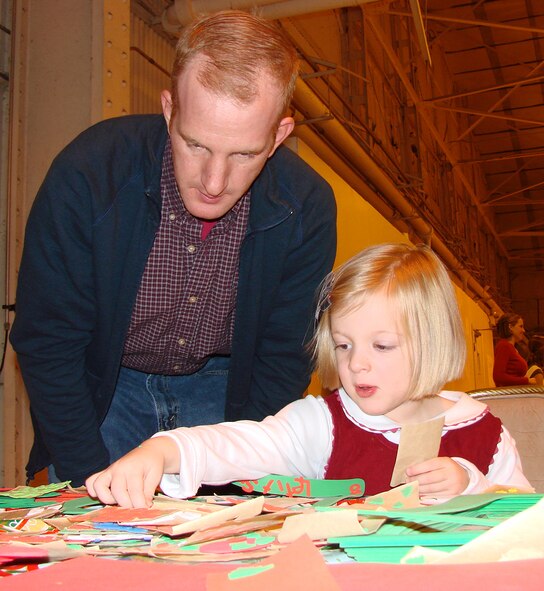 Maj. Joe DiNatalie helps his daughter, Mariel, 3, create a holiday project during "Breakfast with Santa" Dec. 8 in Hangar 170. (U.S. Air Force photo by Tech. Sgt. Mary Davis) 
