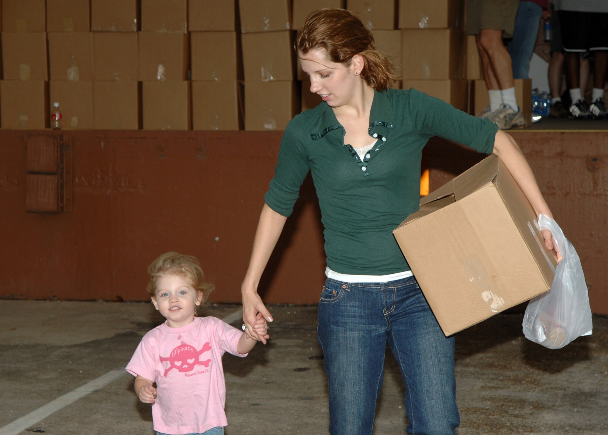 A Barksdale Airman and her daughter carry a food box outside the 2nd Logistics Readiness Squadron warehouse at Barksdale Air Force Base, La., Dec. 11.   Angel Food Ministries visited Barksdale, for the first time, to deliver more than 220 boxes of food to Airmen and their families.(U.S. Air Force photo by Airman 1st Class Joanna M. Kresge)(Released)