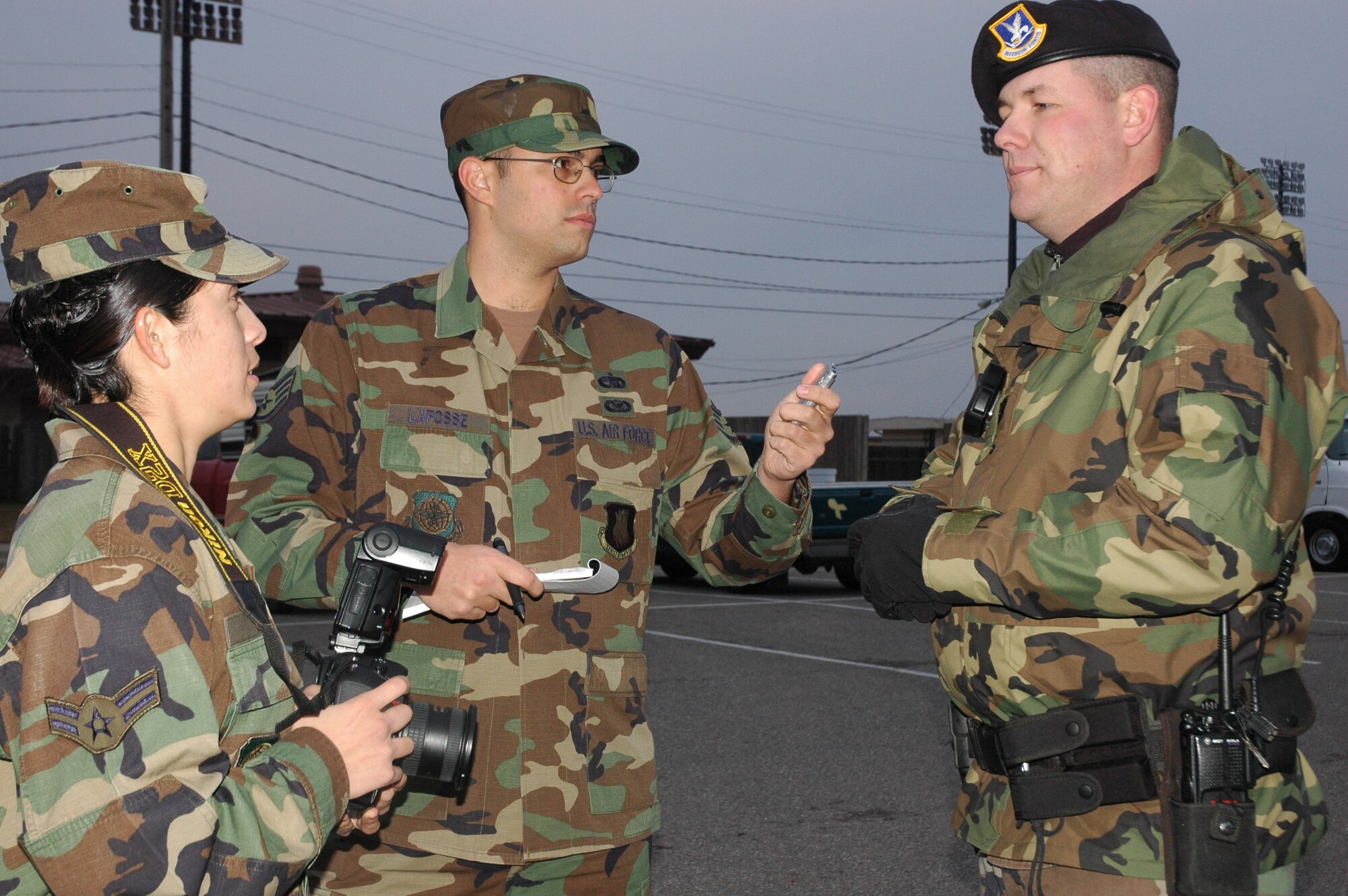 MCCONNELL AIR FORCE BASE, Kan. -- Airman 1st Class Maria Ruiz and Staff Sgt. Ronald Lafosse II, 22nd Air Refueling Wing Public Affairs, gathered information from Staff Sgt. David Burchess, 22nd Security Forces Squadron, before documenting on an incident.  Public Affairs gather information to be released to local media.  Public Affairs photographers are on call to document mishaps, natural disasters, rescue and recovery, and investigation boards for Security Forces, Air Force Office of Special Investigations, Disaster Preparedness, flying or ground safety offices, and other emergency response agencies.  (Photo by Tech. Sgt. Chyrece Campbell)