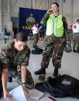 MCCONNELL AIR FORCE BASE, Kan. -- Airman 1st Class Jessica Lockoski, left, and Senior Airman Amanda Currier, 22nd Air Refueling Wing Public Affairs, make preparations for a news release for the on-scene commander’s approval after a simulated explosion June 27, during a Major Accident Response Exercise. (Photo by Erin Lewis)